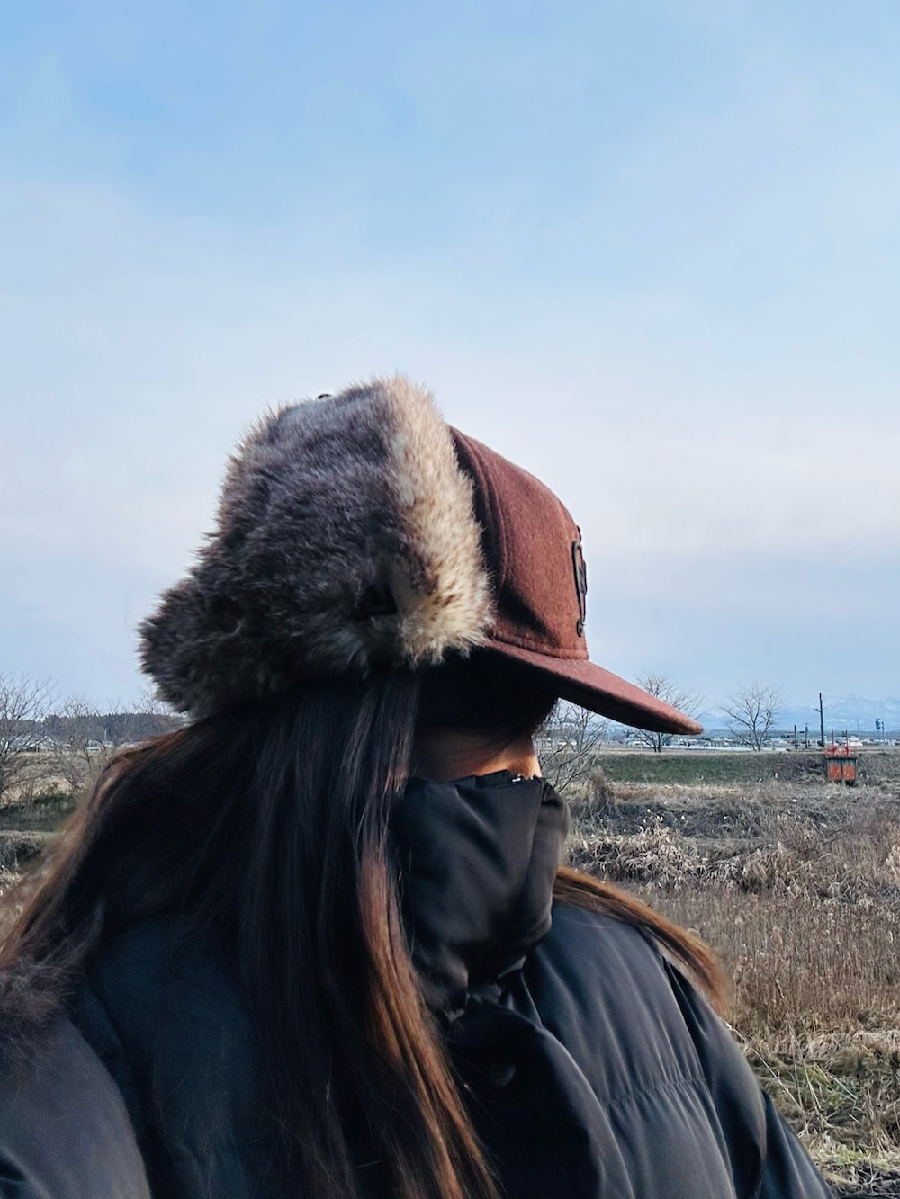 グレー系のスウェット、グリーン系のワンピース、ホワイト系のスニーカーを着用したレディースの冬コーディネートの3枚目の写真