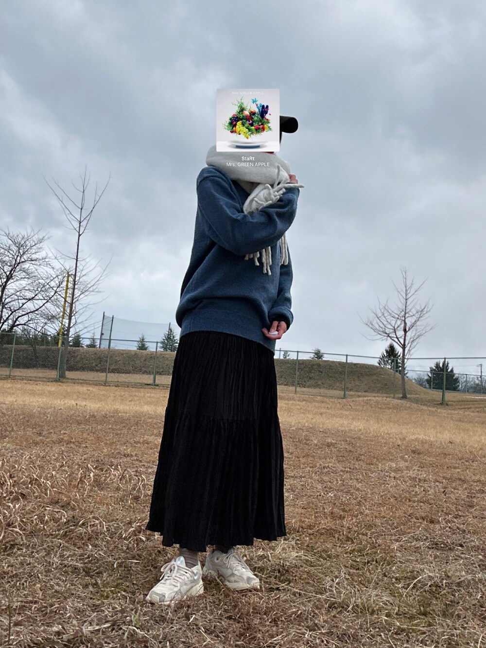 ブルー系のニット/セーター、ブラック系のスカート、ベージュ系のスニーカーを着用したレディースの冬コーディネートの2枚目の写真