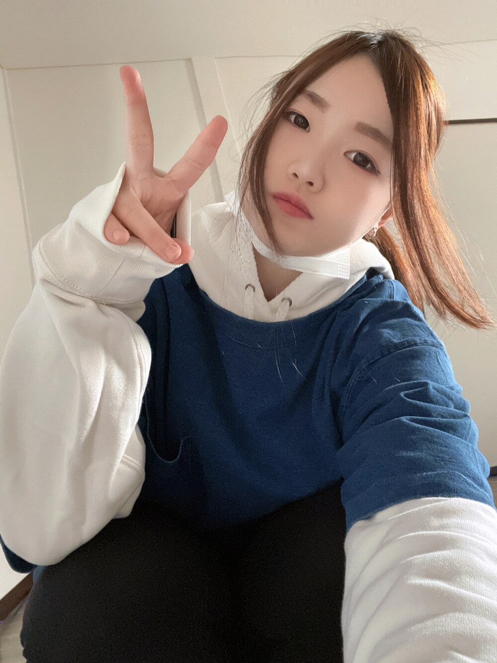 ブルー系のTシャツ/カットソー、ホワイト系のパーカー、ブラック系のスラックスを着用したレディースの冬コーディネートの2枚目の写真