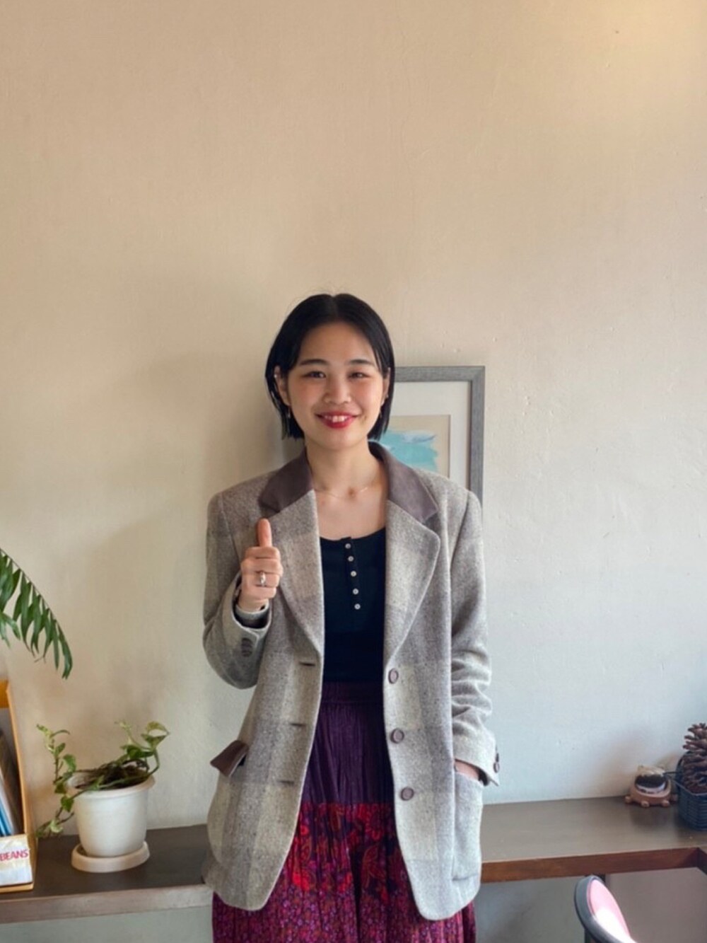 ベージュ系のテーラードジャケット、レッド系のスカート、ブラック系のスニーカーを着用したレディースの春コーディネートの3枚目の写真