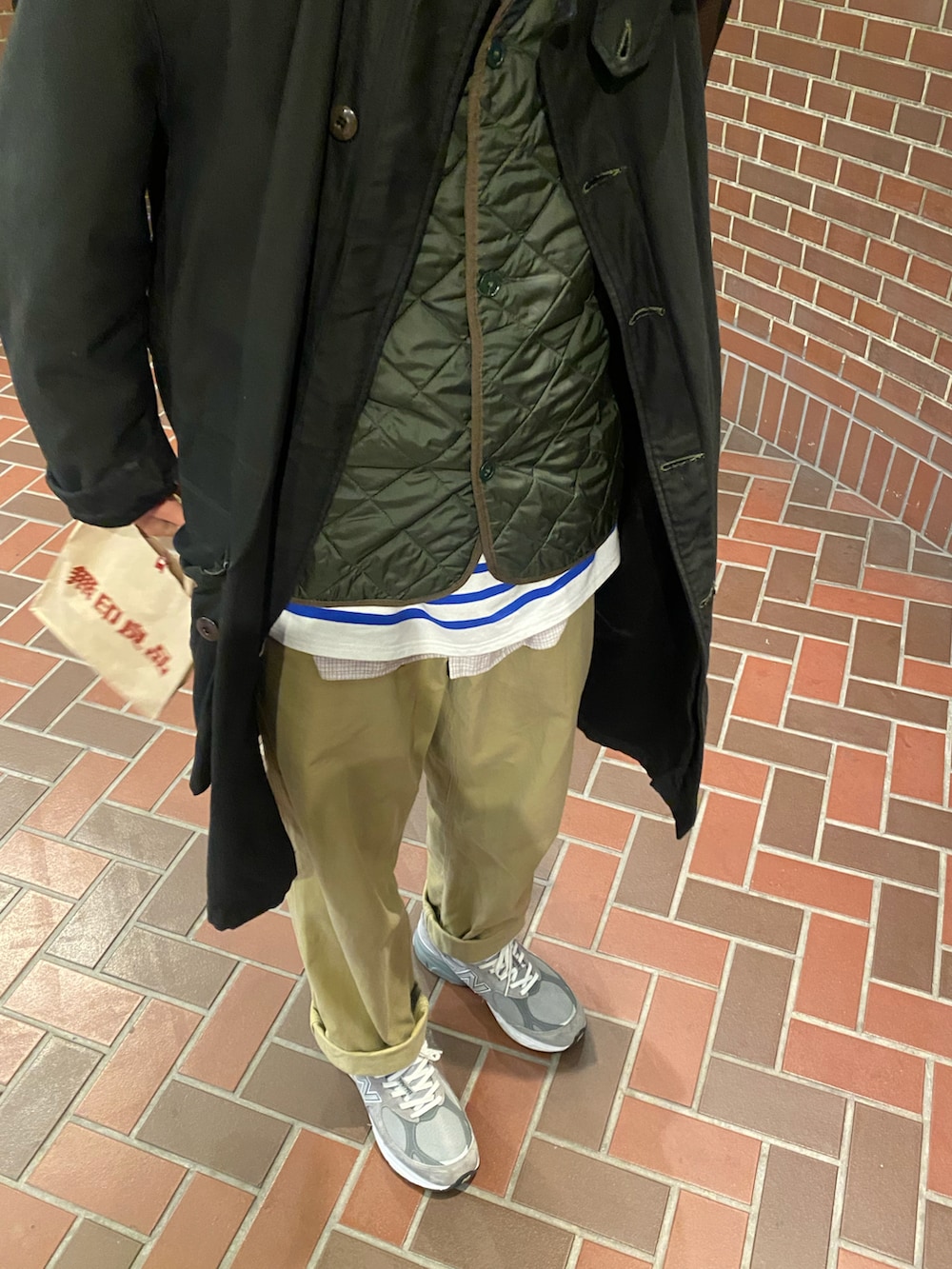 その他のスカート、ブラック系のその他アウター、レッド系のショルダーバッグを着用したレディースの冬コーディネートの2枚目の写真