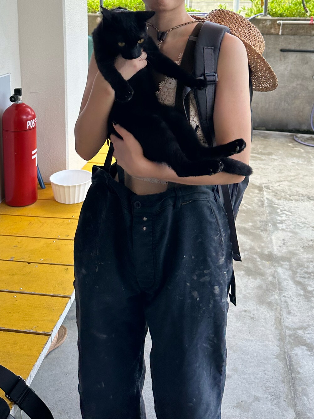 ブラック系のカーゴパンツ、ベージュ系のキャミソール、グリーン系のサスペンダーを着用したレディースの秋コーディネートの2枚目の写真