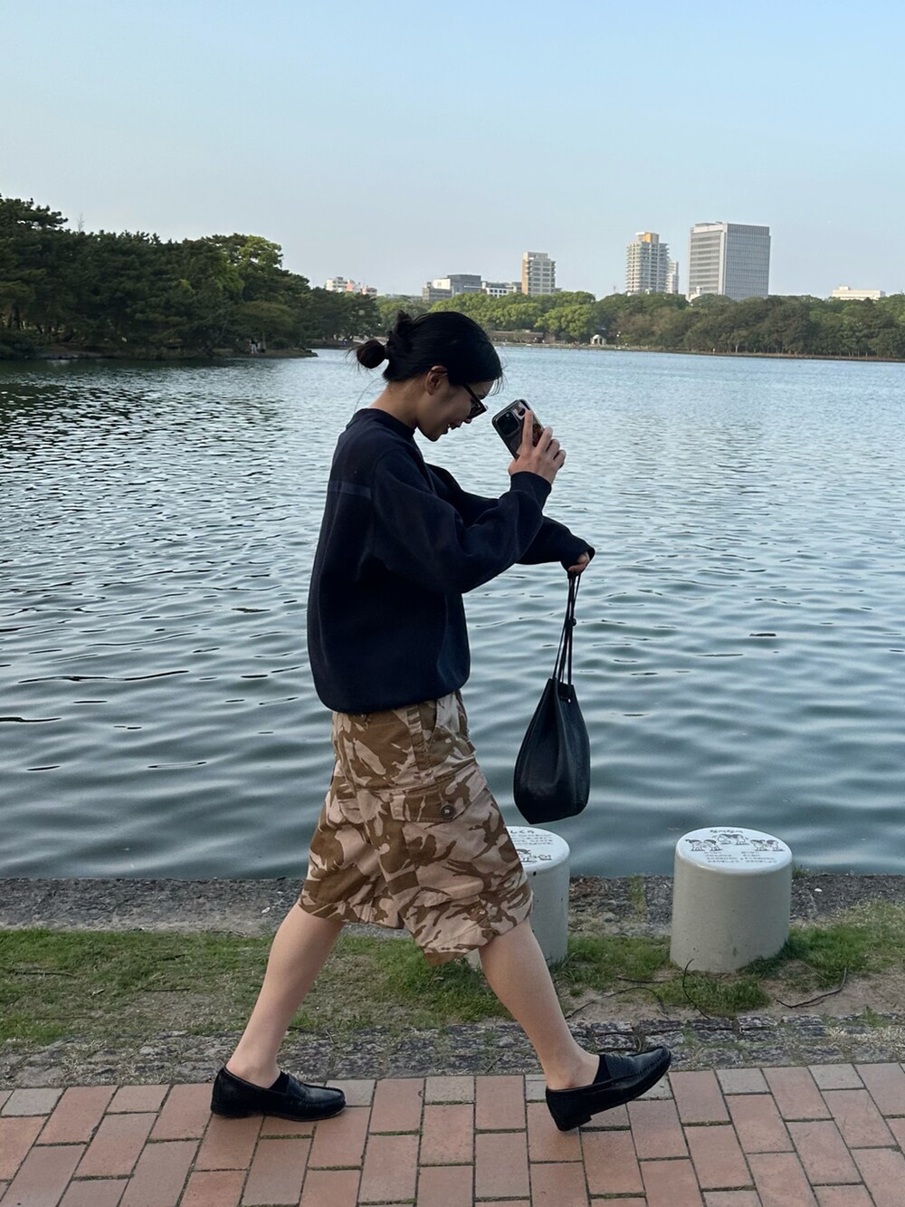 ブルー系のスウェット、ブラウン系のパンツ、ブラック系のローファーを着用したレディースの春コーディネートの2枚目の写真