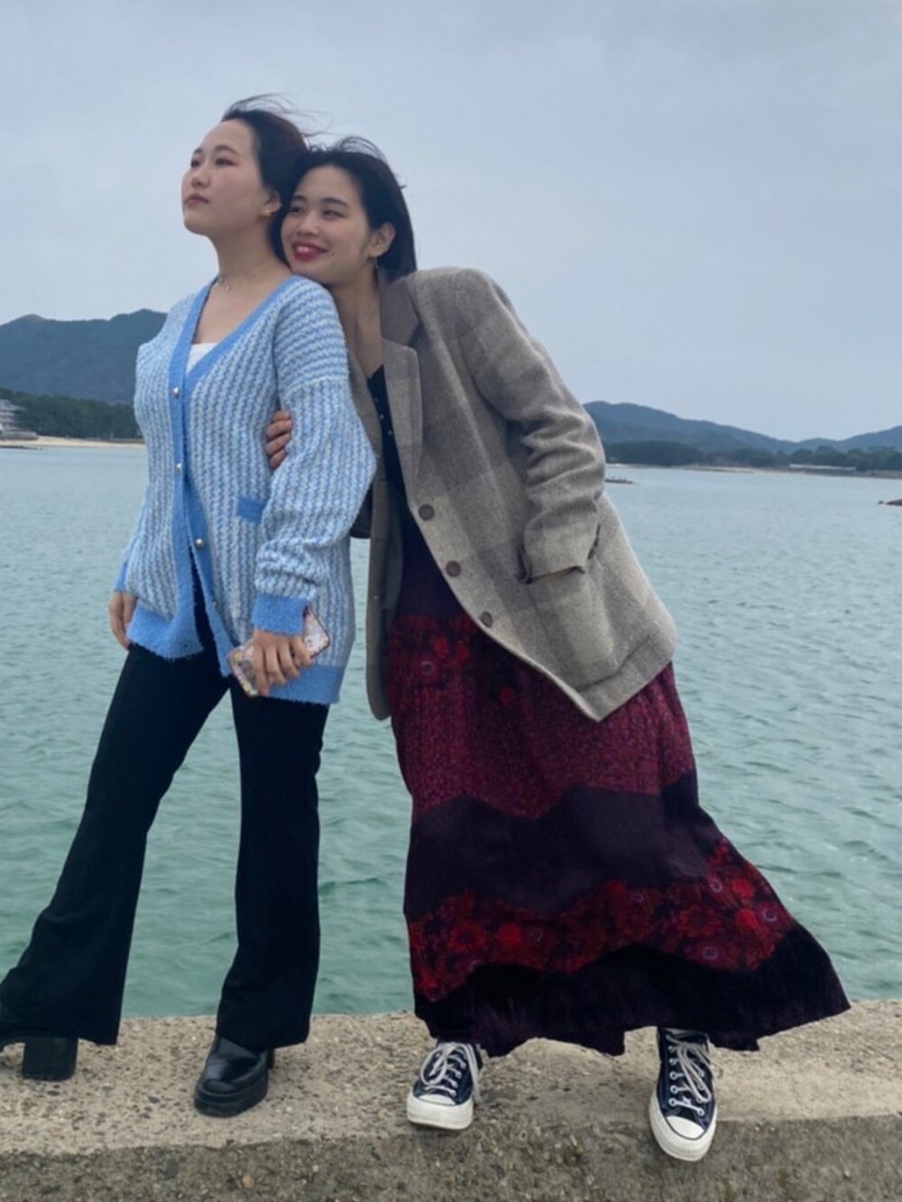 ベージュ系のテーラードジャケット、レッド系のスカート、ブラック系のスニーカーを着用したレディースの春コーディネートの2枚目の写真