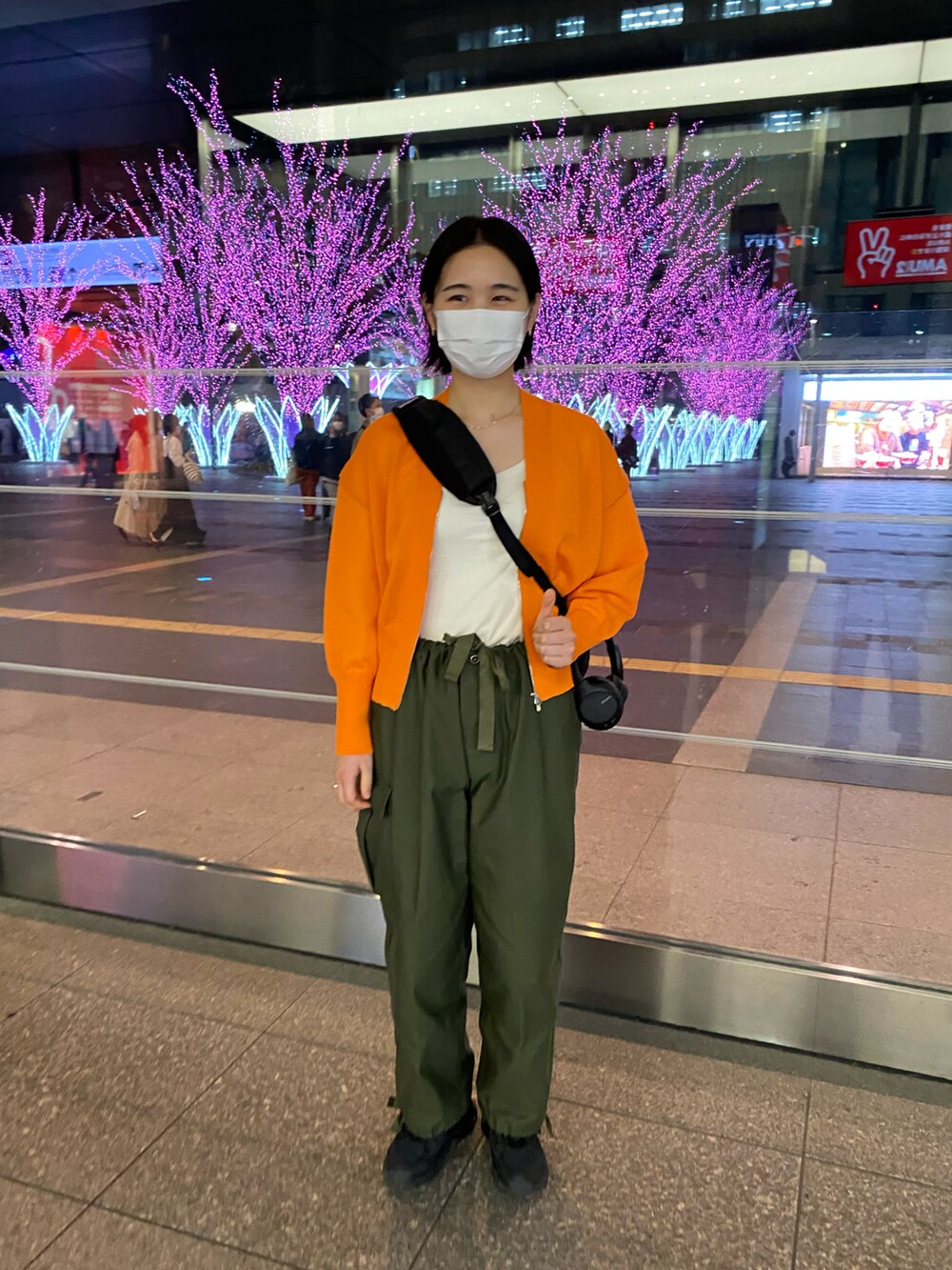 オレンジ系のカーディガン/ボレロを着用したレディースの春コーディネートの2枚目の写真