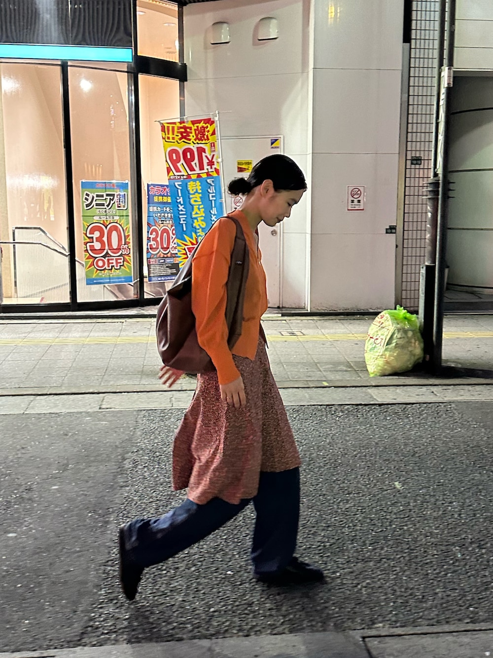 ピンク系のスカート、オレンジ系のカーディガン/ボレロを着用したレディースの夏コーディネートの3枚目の写真