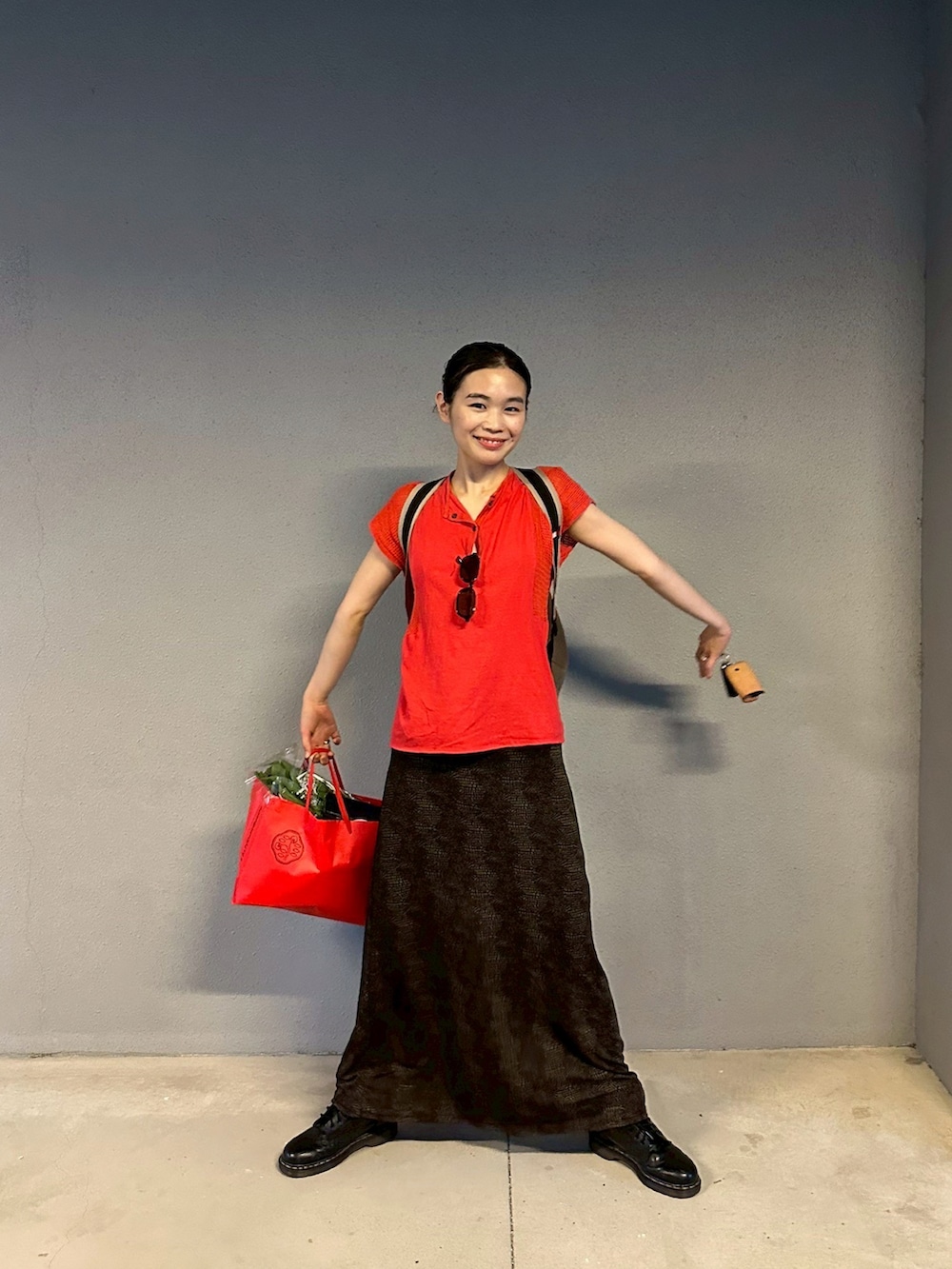 ブラック系のスカート、ブラック系のブーツを着用したレディースの夏コーディネートの2枚目の写真