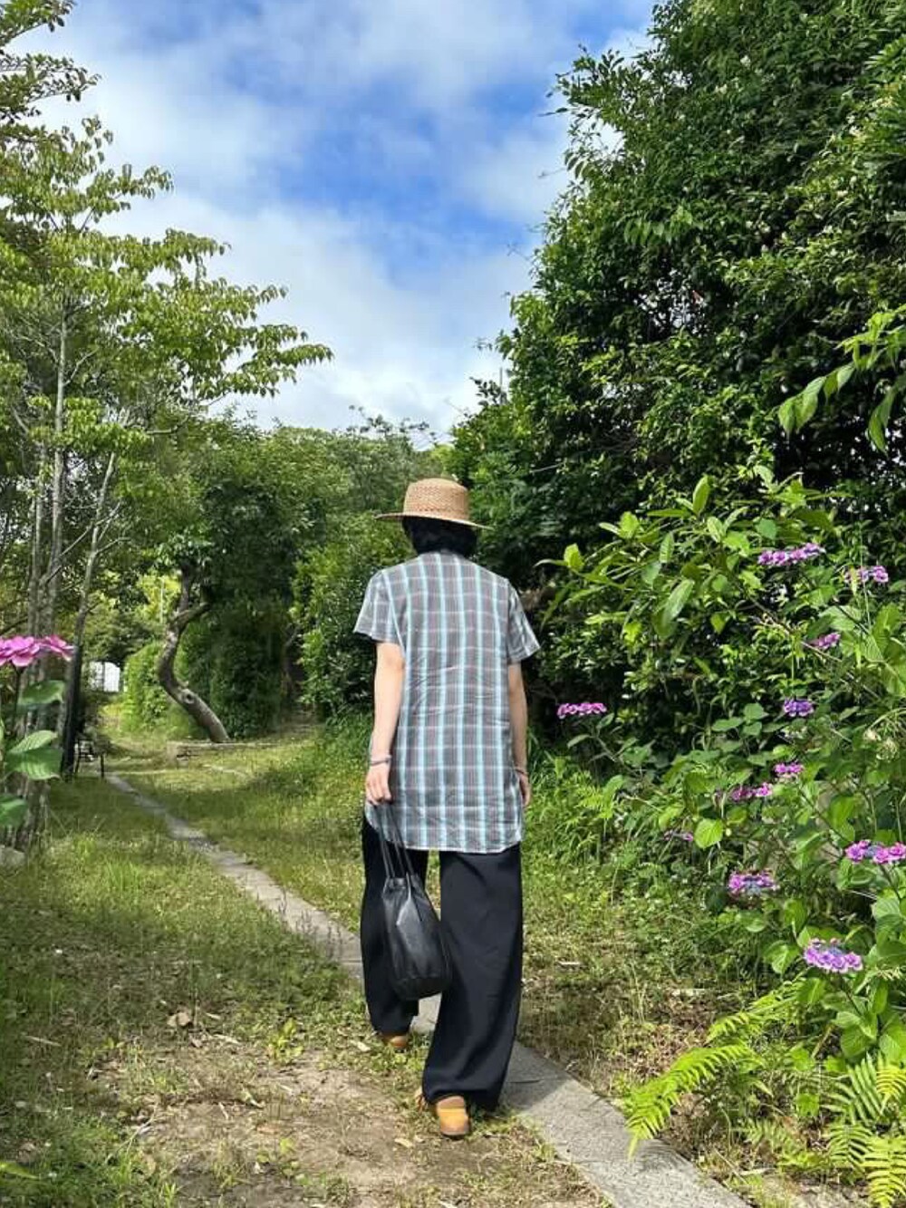 ブルー系のシャツ/ブラウス、ブラック系のバッグ、ブラウン系のスニーカーを着用したレディースの春コーディネートの3枚目の写真