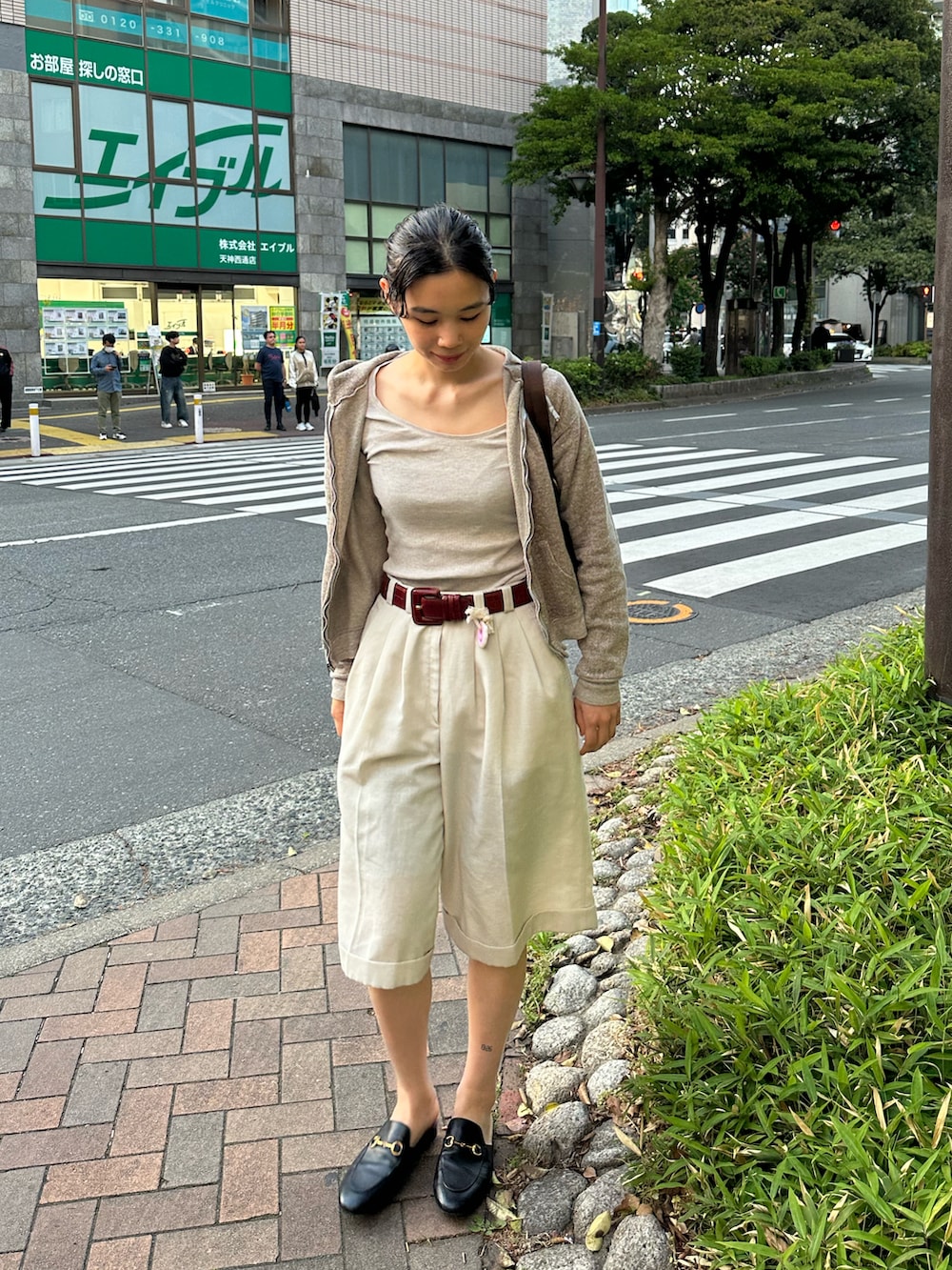 ブラウン系のパーカーを着用したレディースの春コーディネートの2枚目の写真