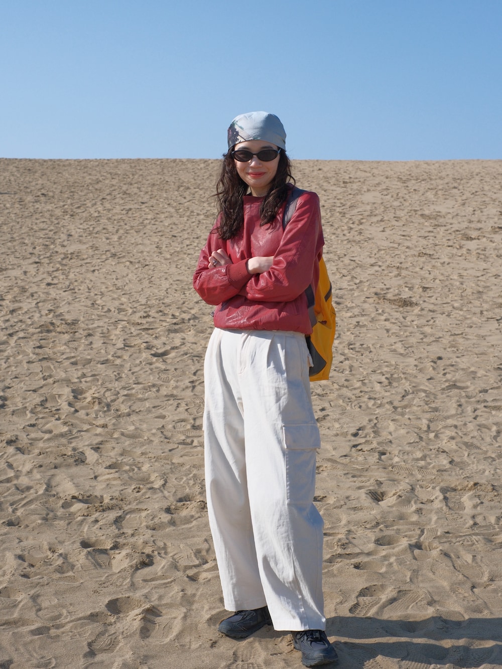 ホワイト系のカーゴパンツ、レッド系のスウェット、ブラック系のスニーカーを着用したレディースの春コーディネートの2枚目の写真