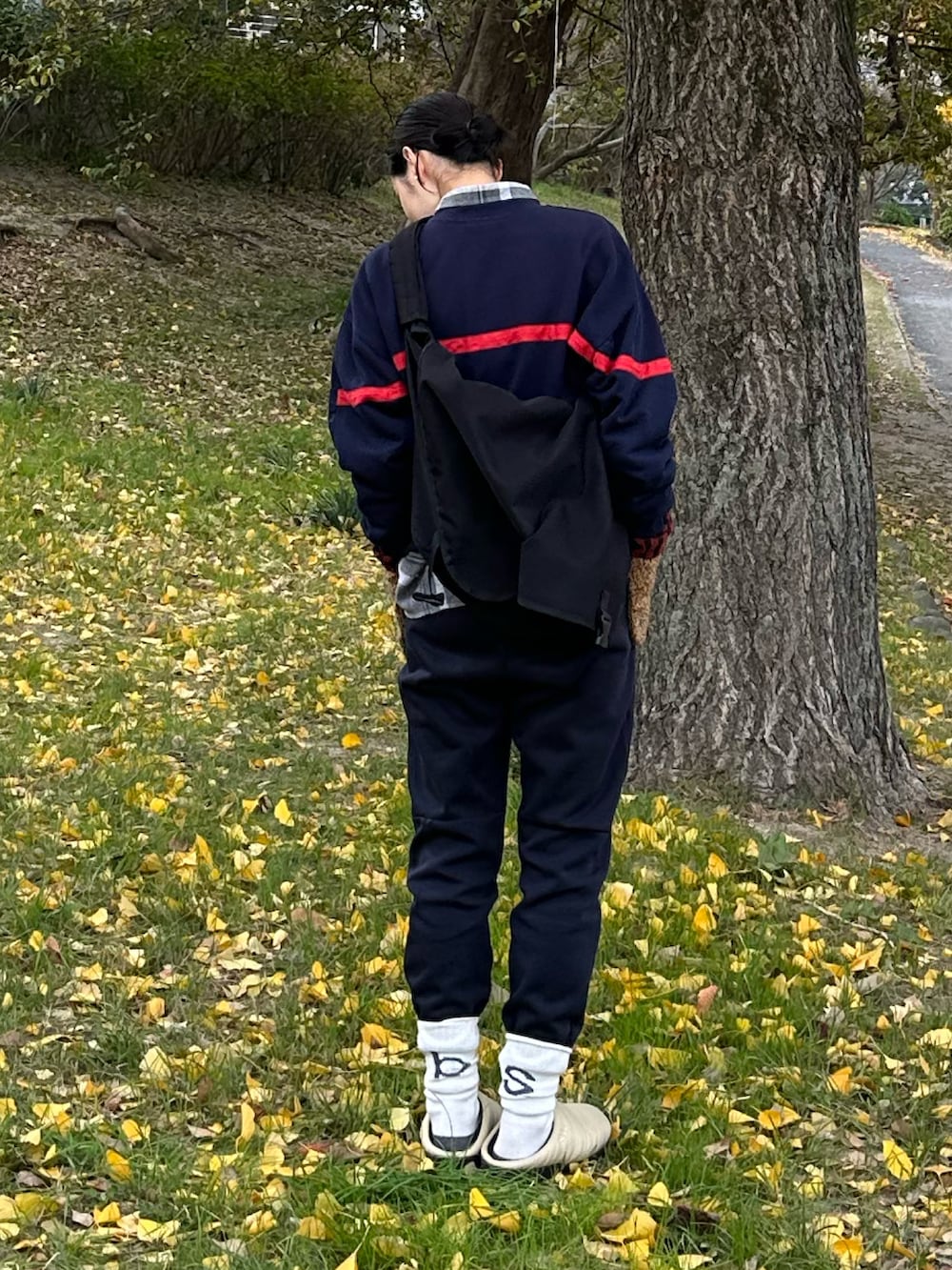 ブルー系のスウェット、ブラック系のメッセンジャーバッグ、ブルー系のスウェットパンツを着用したレディースの冬コーディネートの2枚目の写真