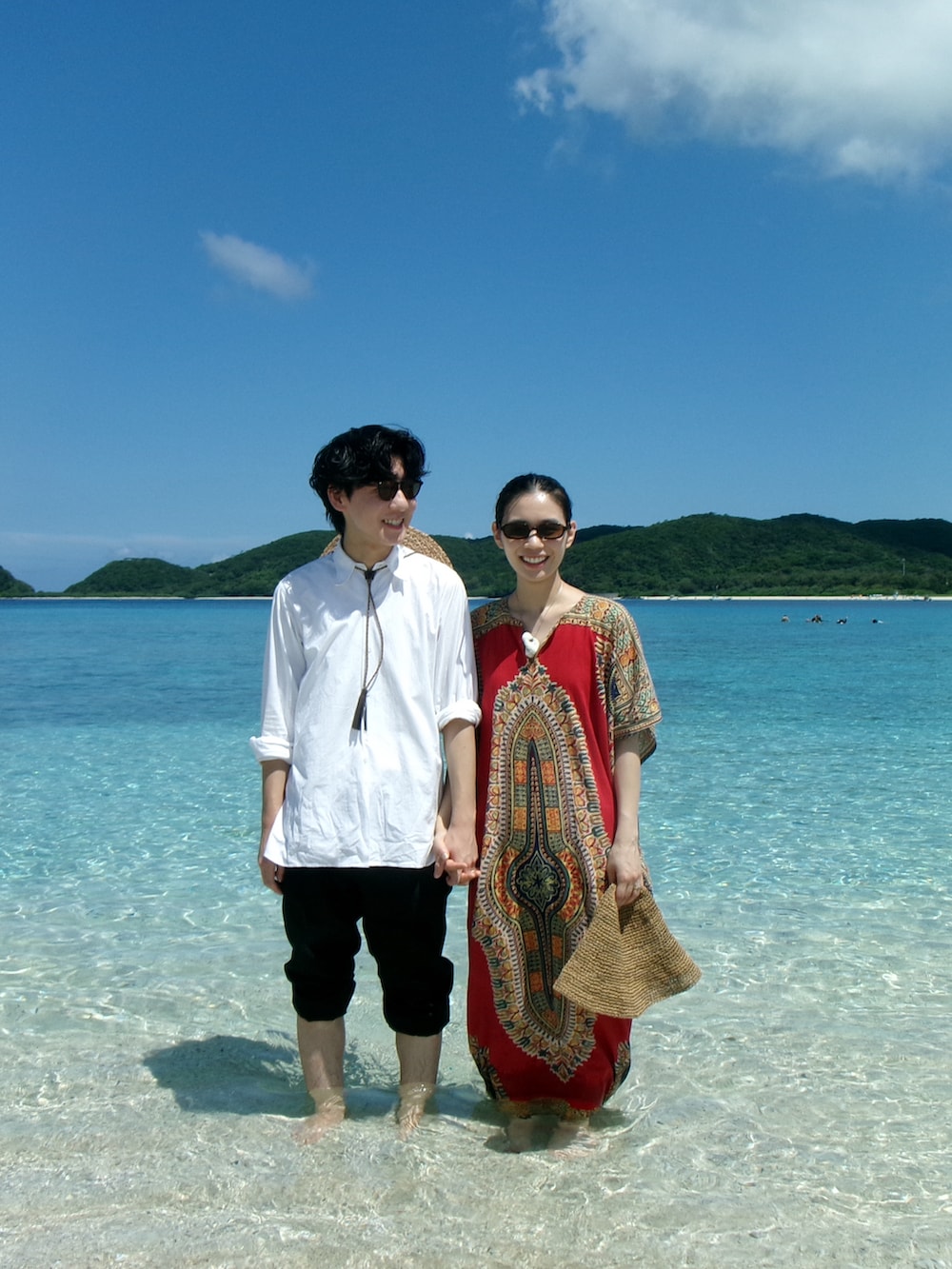 レッド系のワンピース、ブラック系のサンダルを着用したレディースの夏コーディネートの3枚目の写真