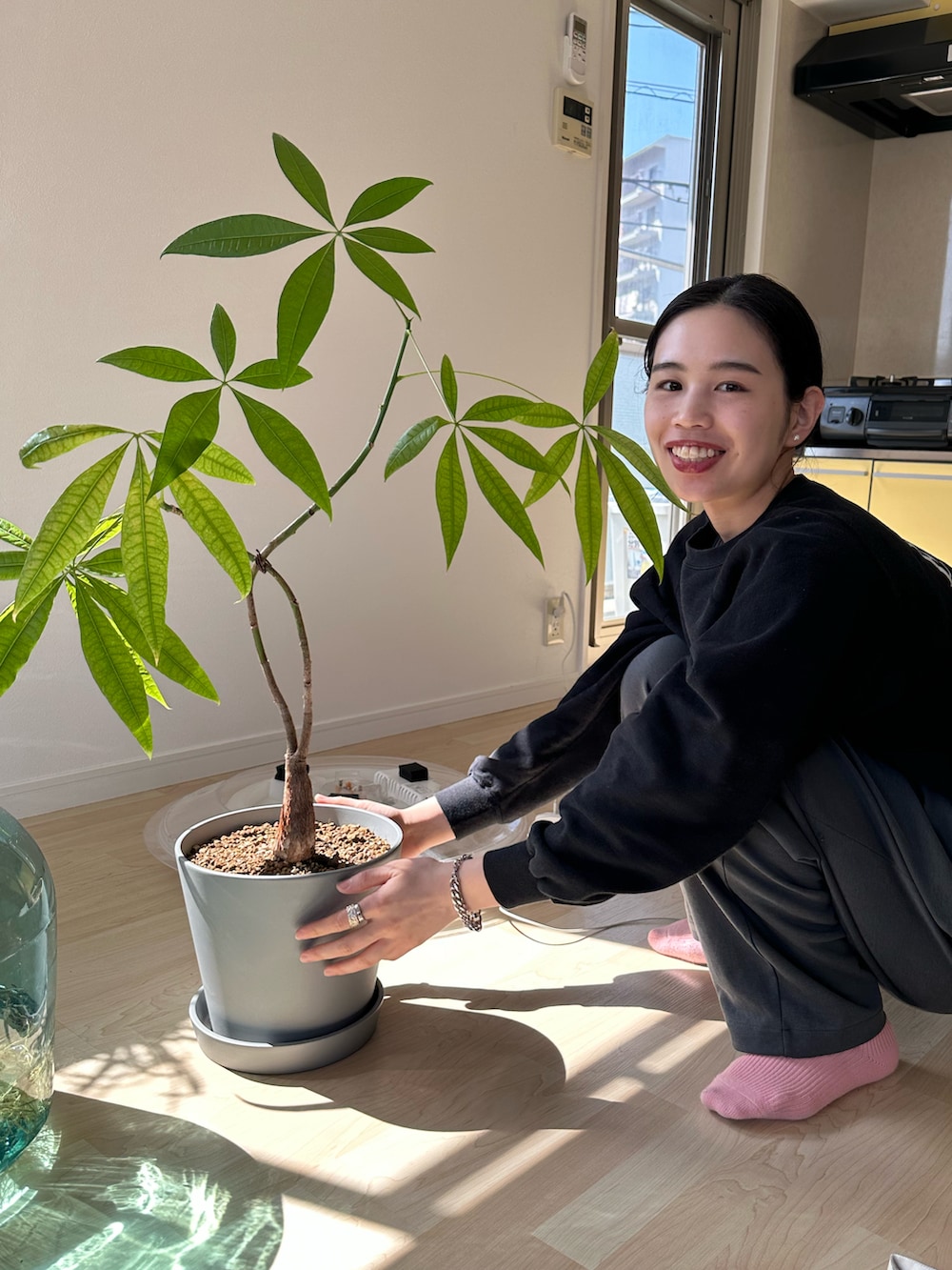 グリーン系のスウェットパンツ、ベージュ系のサンダル、ブラック系のスウェットを着用したレディースの春コーディネートの2枚目の写真