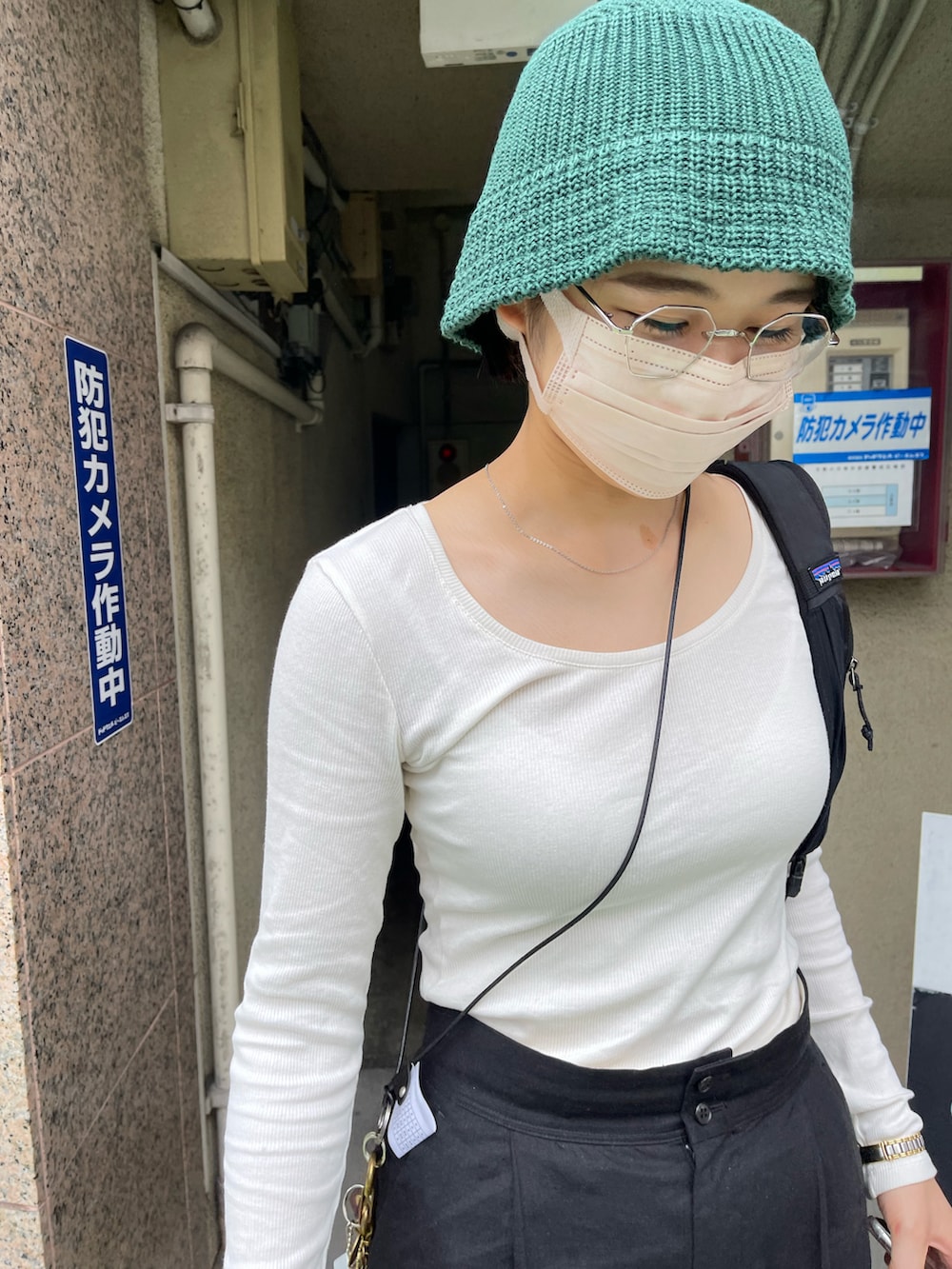 グレー系のトップス、ブラック系のパンツ、ブラック系のスニーカーを着用したレディースの秋コーディネートの2枚目の写真