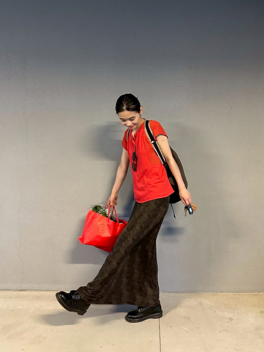 ブラック系のスカート、ブラック系のブーツを着用したレディースの夏コーディネートの3枚目の写真