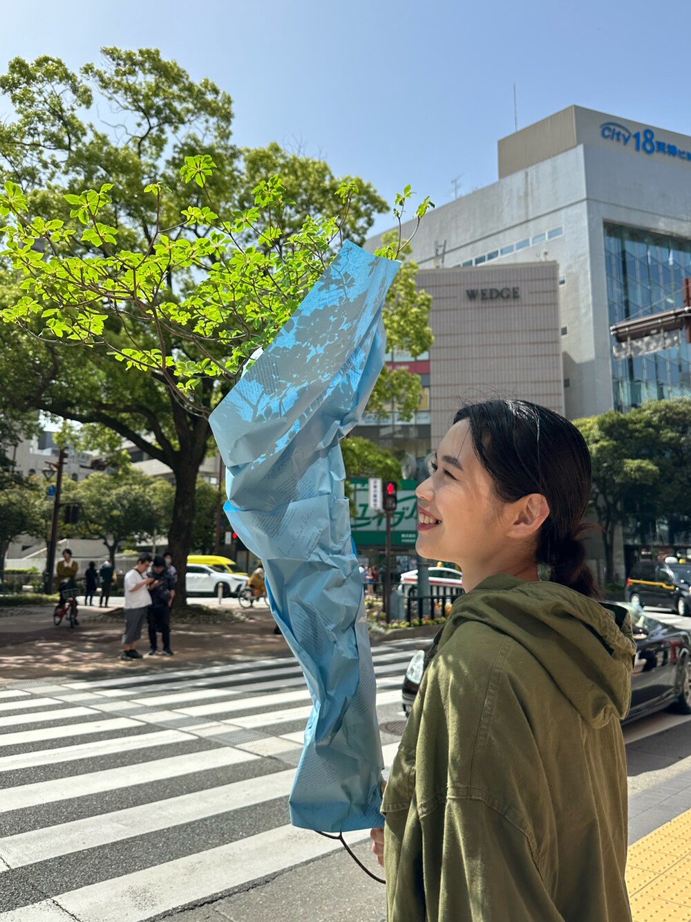 グリーン系のミリタリージャケット、ホワイト系のパンツ、グリーン系のスニーカーを着用したレディースの春コーディネートの2枚目の写真