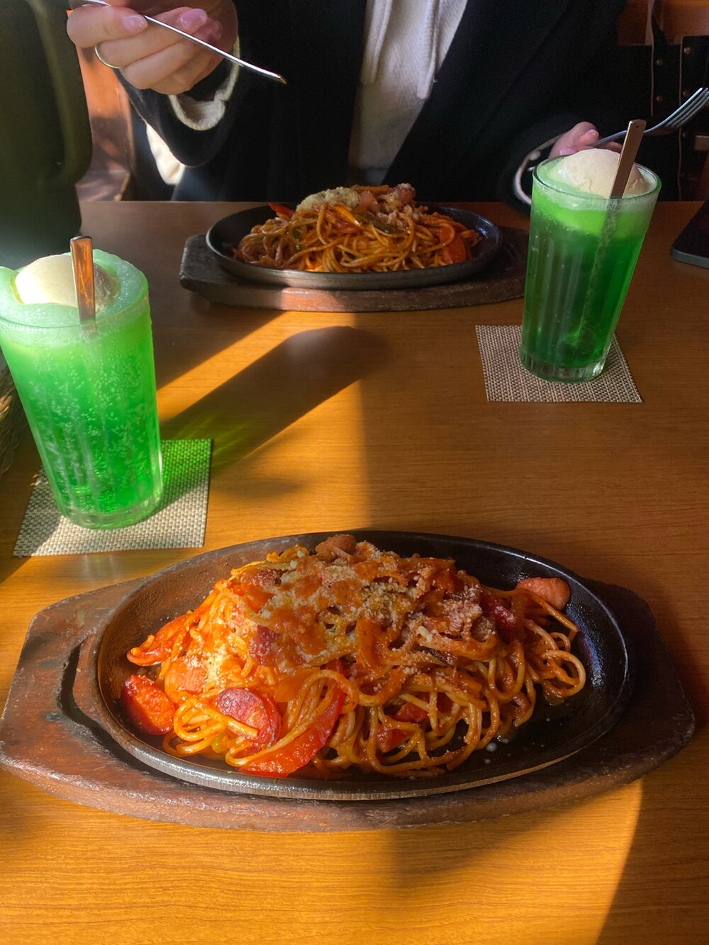 グリーン系のミリタリージャケット、レッド系のスカート、ブラック系のスニーカーを着用したレディースの冬コーディネートの3枚目の写真