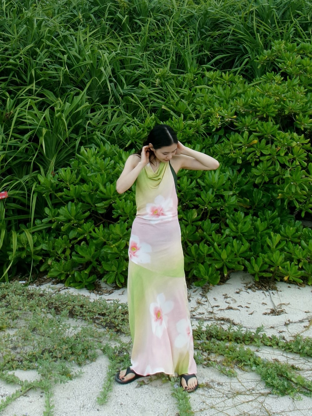 グリーン系のワンピース、ホワイト系のスリッポン、ブラウン系のハットを着用したレディースの夏コーディネートの4枚目の写真