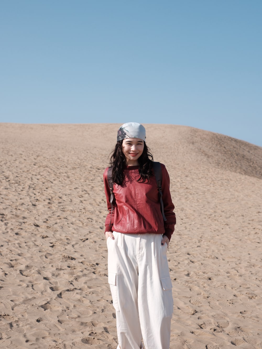 ホワイト系のカーゴパンツ、レッド系のスウェット、ブラック系のスニーカーを着用したレディースの春コーディネートの4枚目の写真