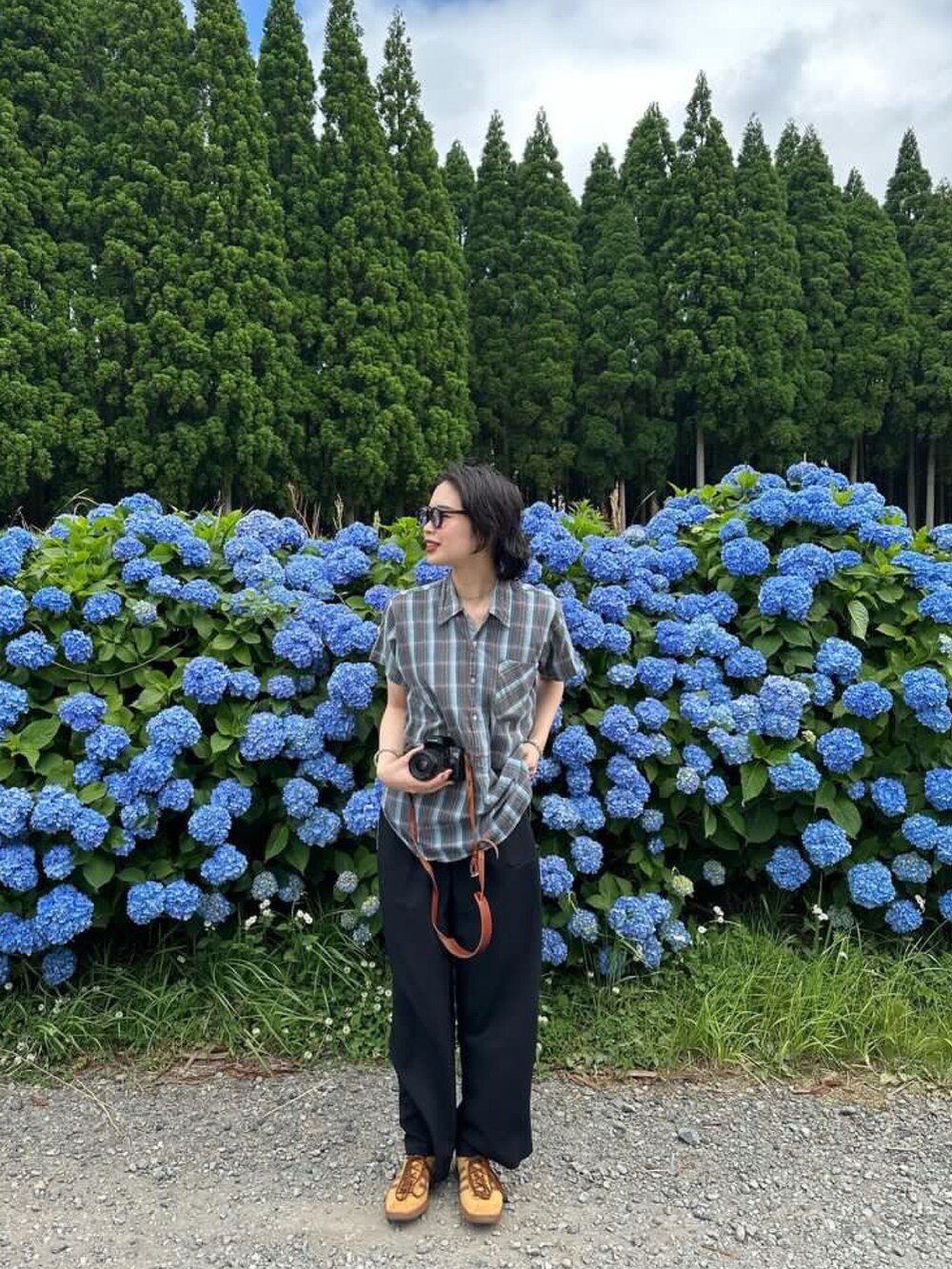 ブルー系のシャツ/ブラウス、ブラック系のバッグ、ブラウン系のスニーカーを着用したレディースの春コーディネートの2枚目の写真