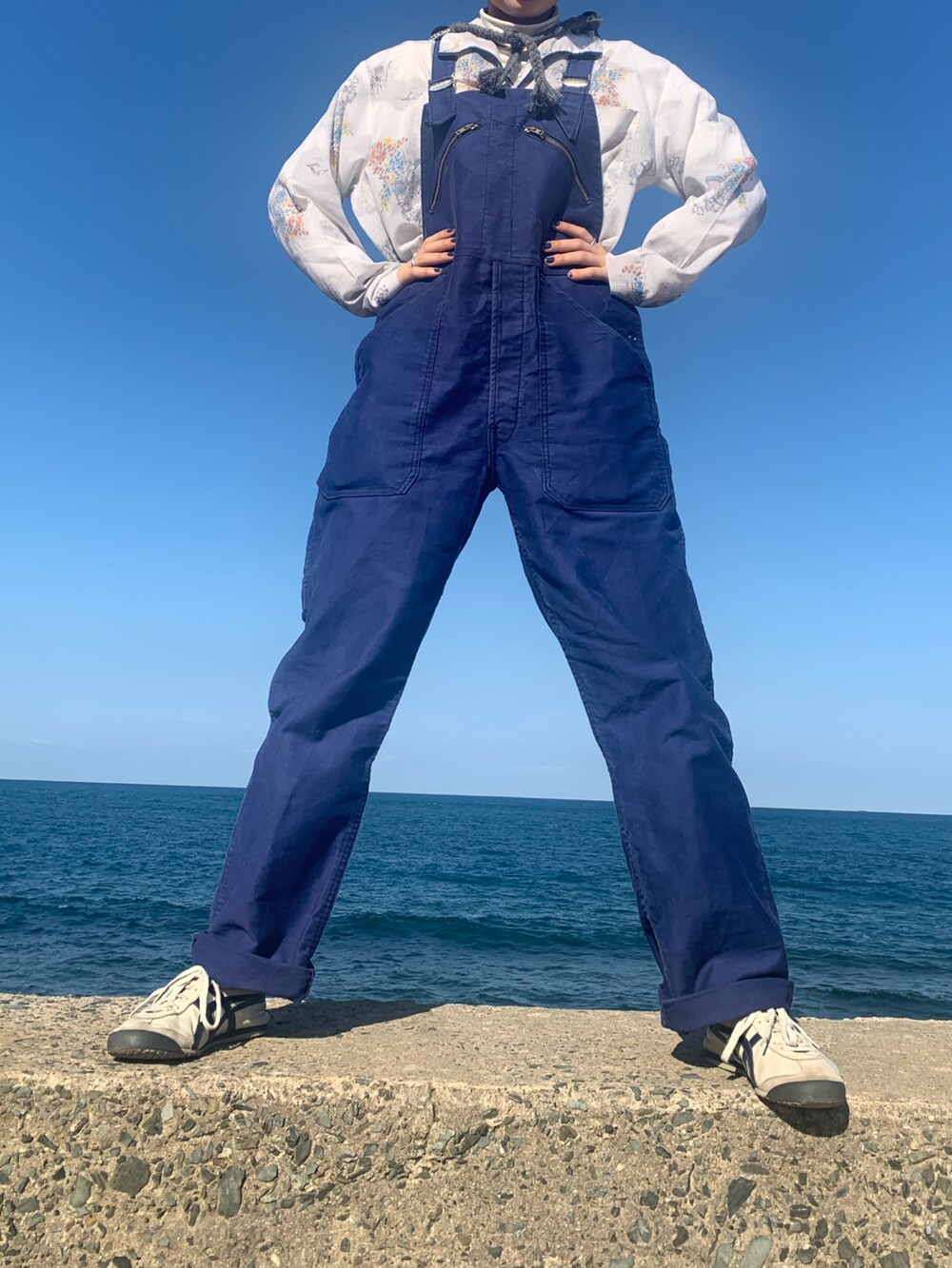 ブルー系のオールインワン・サロペット、グレー系のスニーカー、グレー系のニットキャップ/ビーニーを着用したレディースの冬コーディネートの3枚目の写真