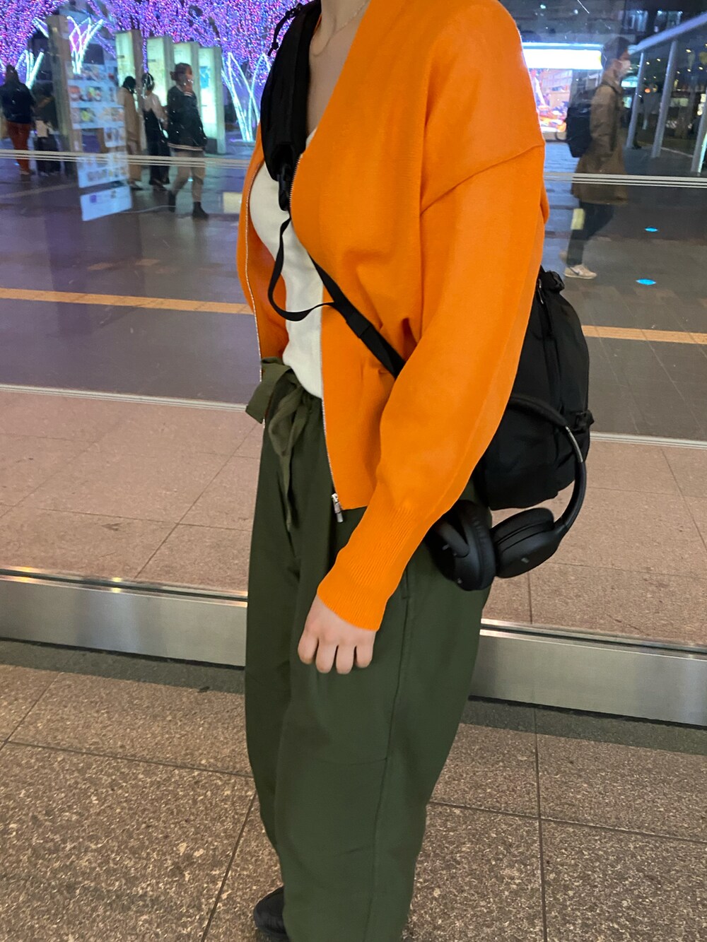 オレンジ系のカーディガン/ボレロを着用したレディースの春コーディネートの3枚目の写真