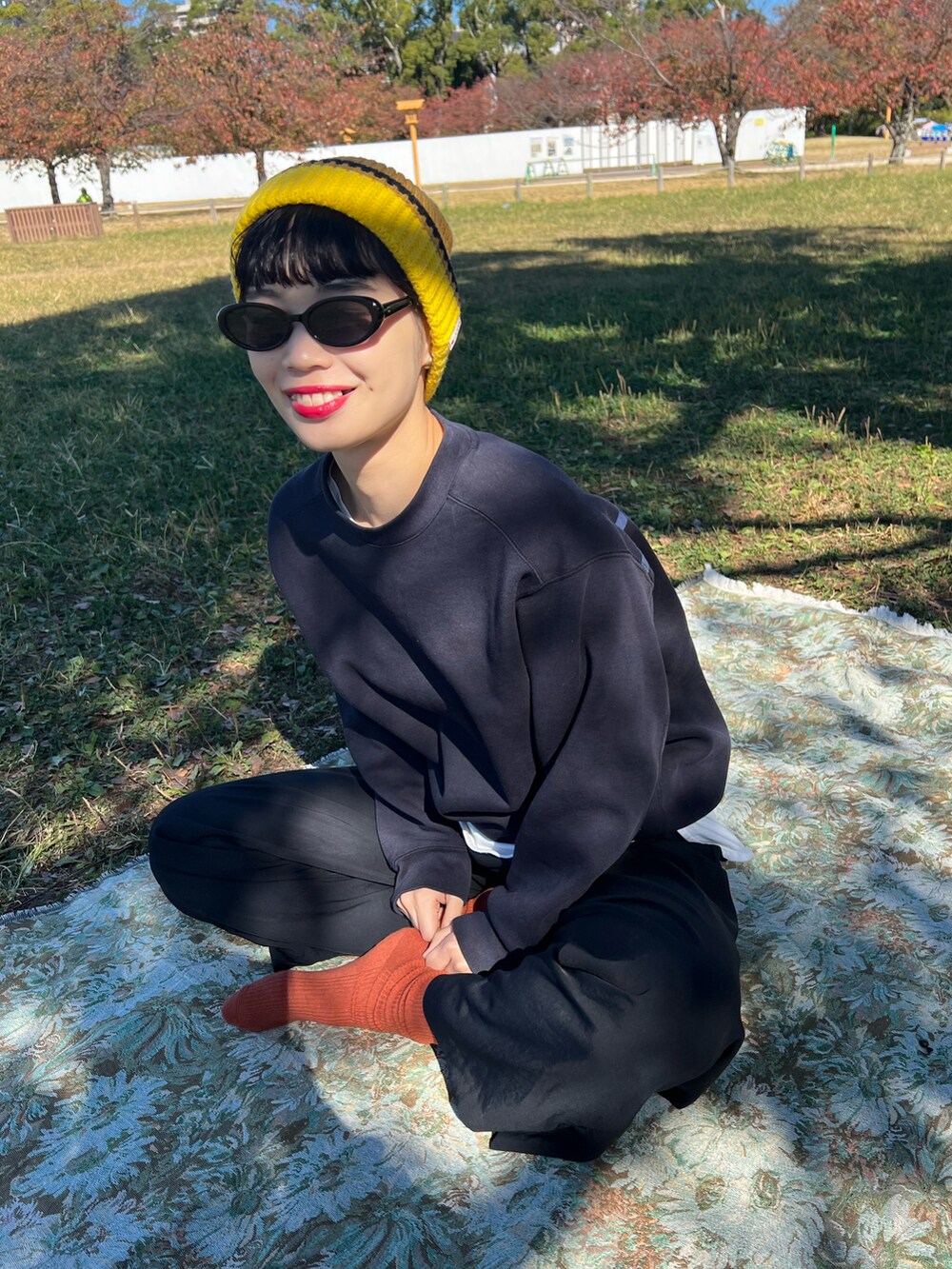 ブラック系のパンツ、グリーン系のスニーカーを着用したレディースの秋コーディネートの2枚目の写真