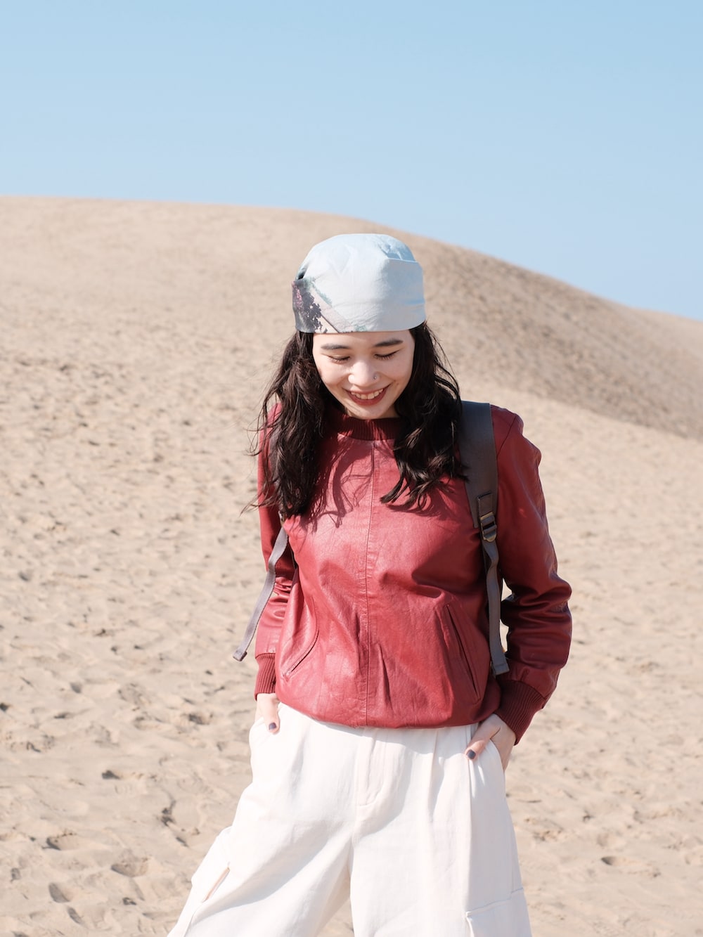 ホワイト系のカーゴパンツ、レッド系のスウェット、ブラック系のスニーカーを着用したレディースの春コーディネートの3枚目の写真