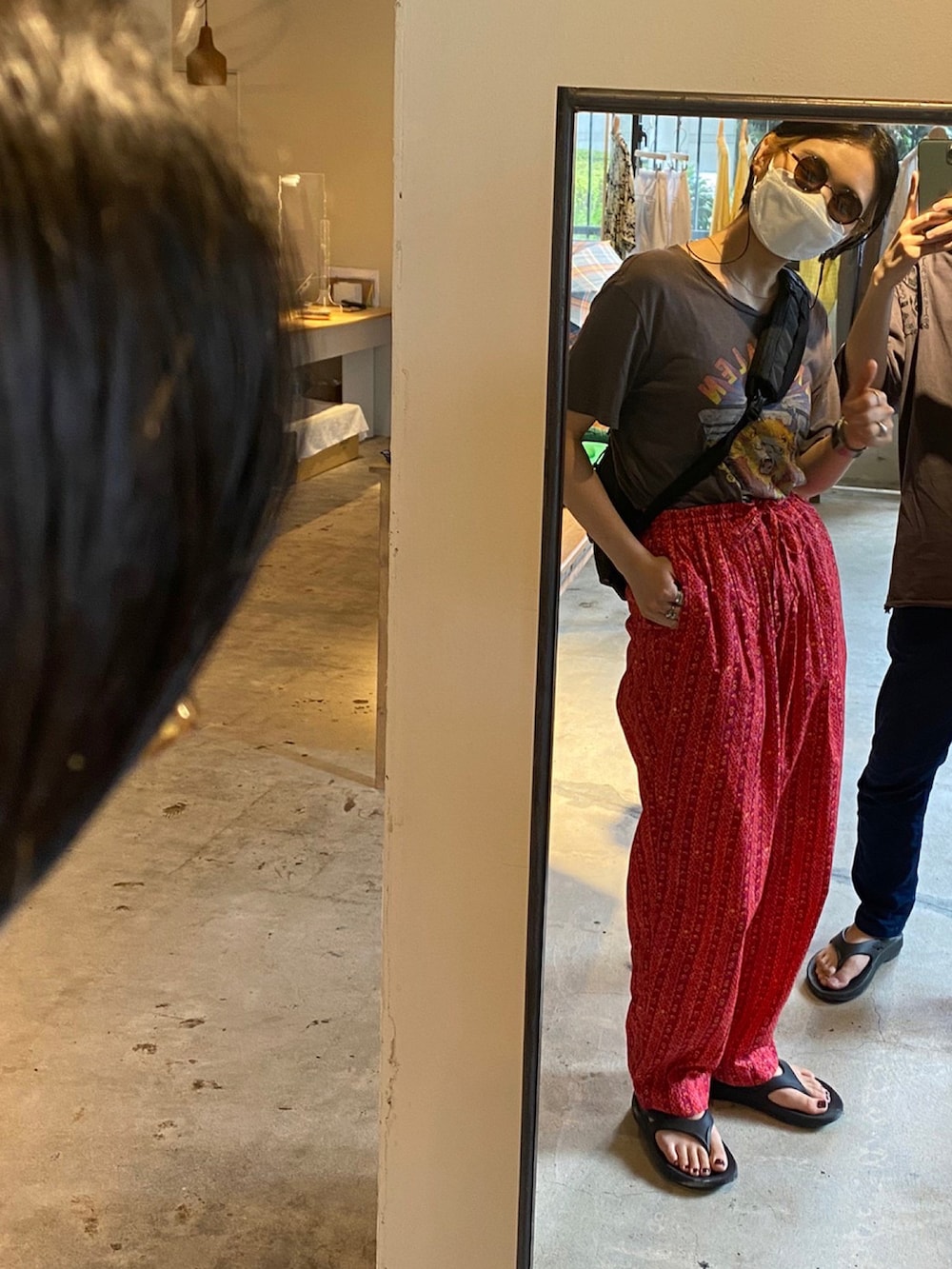 レッド系のパンツ、ブラック系のショルダーバッグ、ブラック系のサンダルを着用したレディースの夏コーディネートの2枚目の写真