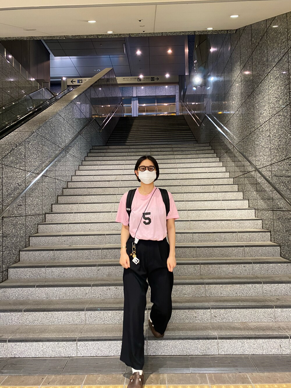 ブラウン系のサンダル、ブラック系のパンツ、ピンク系のTシャツ/カットソーを着用したレディースの秋コーディネートの3枚目の写真