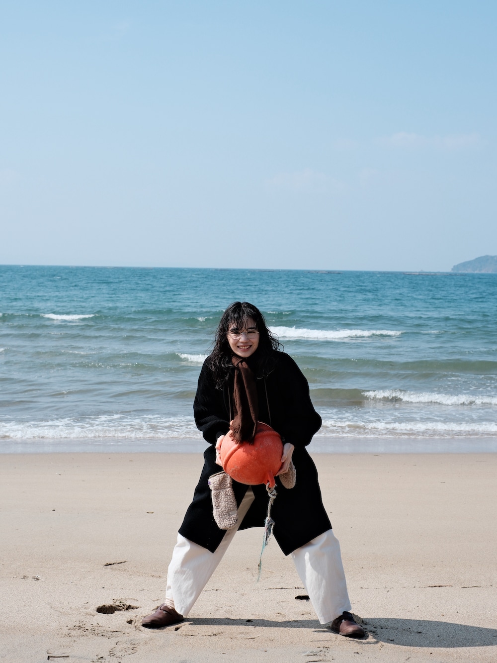 ブラック系のその他アウター、ブラウン系のサンダル、ホワイト系のカーゴパンツを着用したレディースの冬コーディネートの3枚目の写真