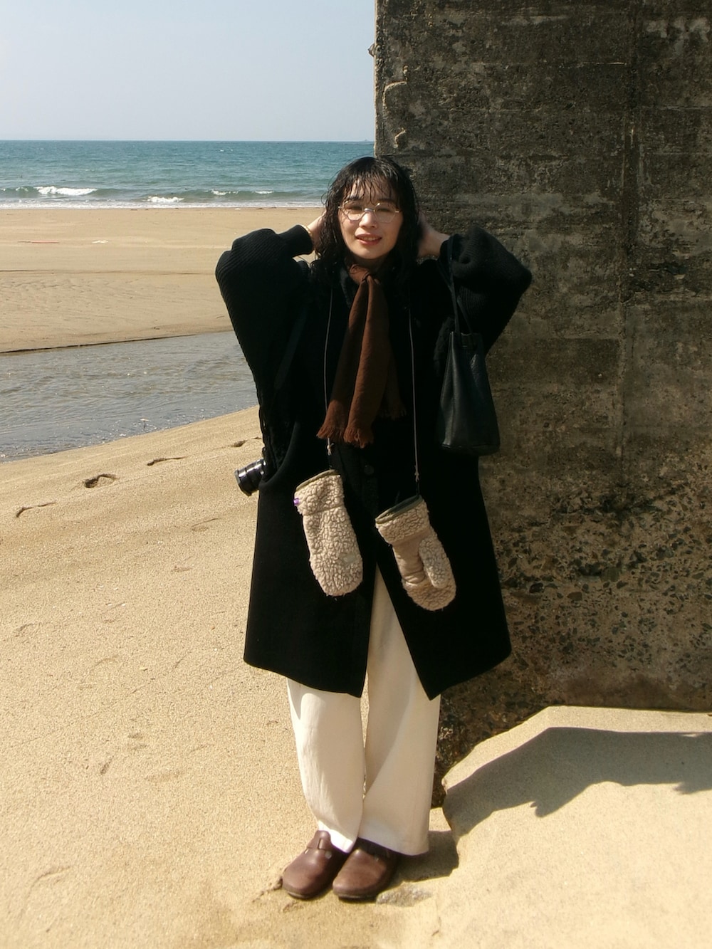 ブラック系のその他アウター、ブラウン系のサンダル、ホワイト系のカーゴパンツを着用したレディースの冬コーディネートの2枚目の写真