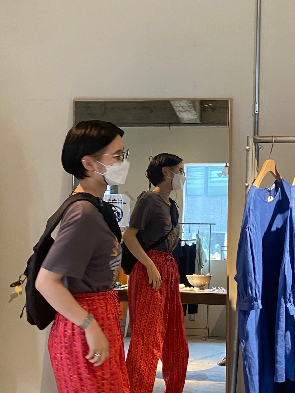 レッド系のパンツ、ブラック系のショルダーバッグ、ブラック系のサンダルを着用したレディースの夏コーディネートの3枚目の写真