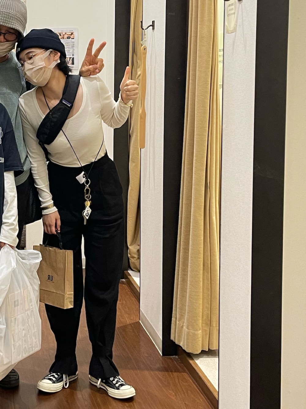 グレー系のトップス、ブラック系のパンツ、ブラック系のスニーカーを着用したレディースの秋コーディネートの3枚目の写真