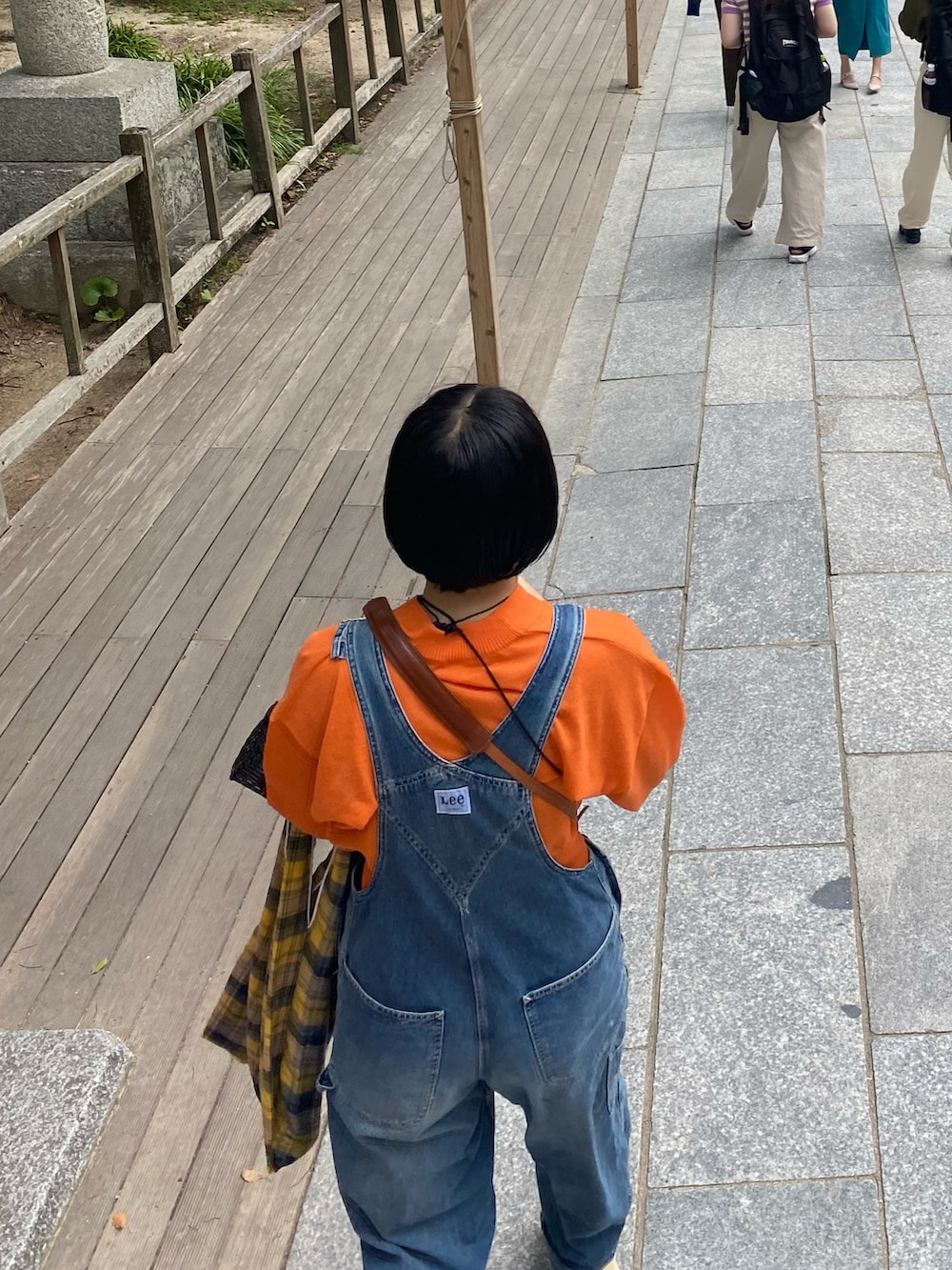 ブルー系のサロペット/オーバーオール、ブラック系のバッグ、ベージュ系のビーチサンダルを着用したレディースの夏コーディネートの3枚目の写真