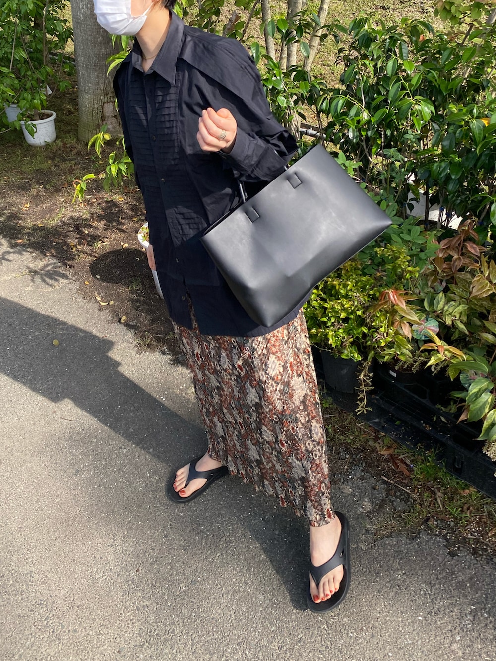 ブラウン系のスカート、ブラック系のシャツ/ブラウス、ブラック系のトートバッグを着用したレディースの春コーディネートの3枚目の写真