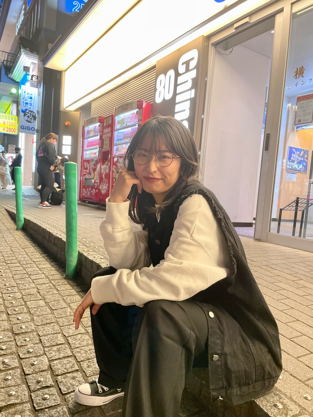 ブラック系のトートバッグ、ブラック系のベスト、ブラック系のスラックスを着用したレディースの冬コーディネートの2枚目の写真