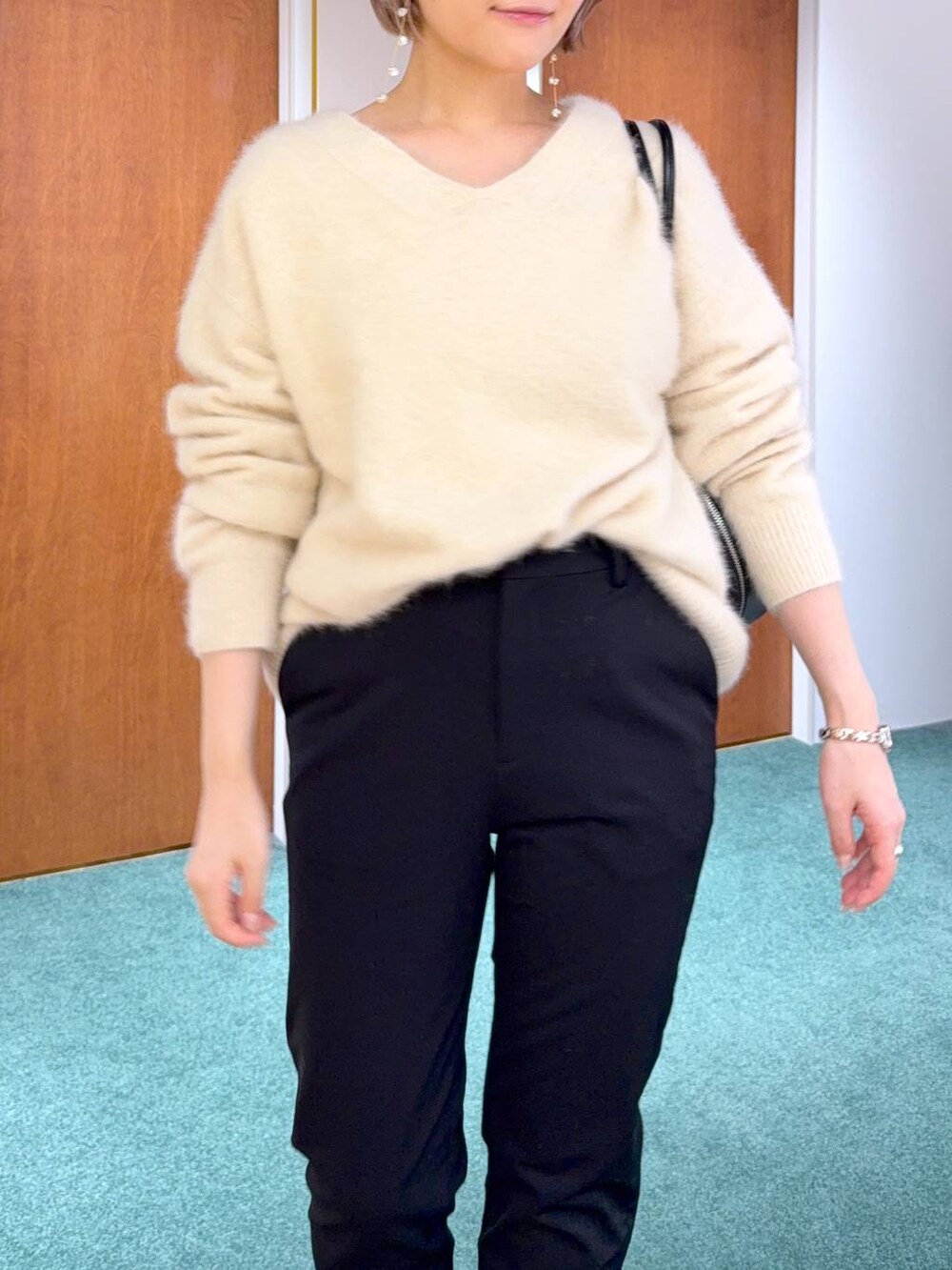 ブラック系のトートバッグ、ベージュ系のニット/セーター、ブラック系のローファーを着用したレディースの冬コーディネートの4枚目の写真