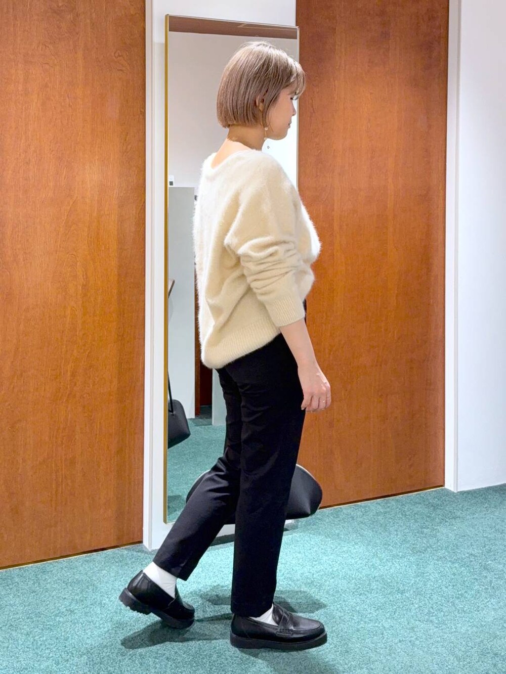 ブラック系のトートバッグ、ベージュ系のニット/セーター、ブラック系のローファーを着用したレディースの冬コーディネートの2枚目の写真