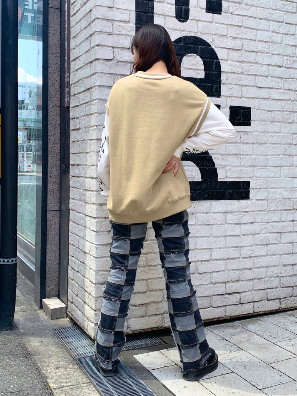 ベージュ系のベスト、ホワイト系のTシャツ/カットソー、ブラック系のデニムパンツを着用したレディースの春コーディネートの2枚目の写真