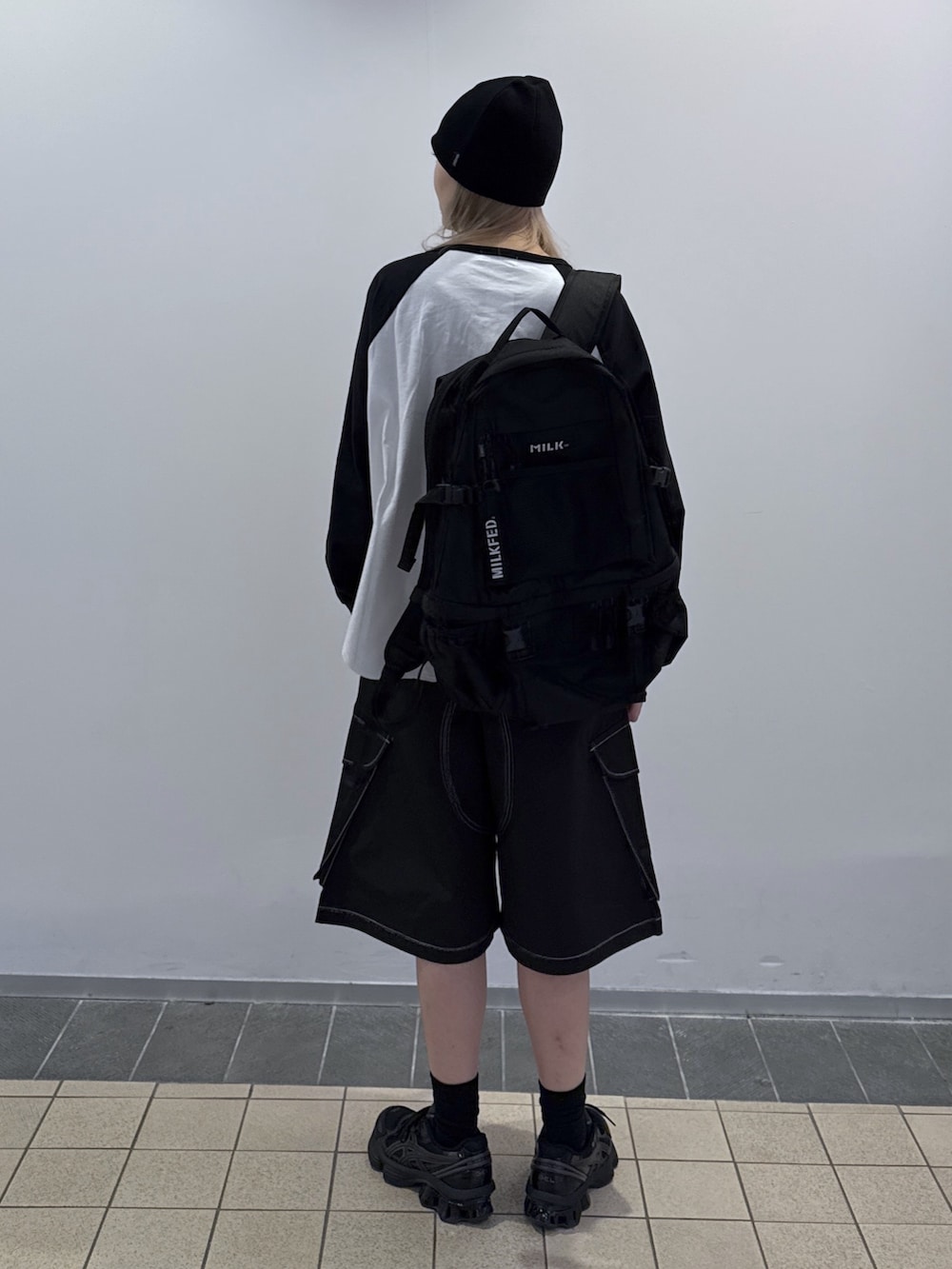 ブラック系のTシャツ/カットソー、ブラック系のカーゴパンツ、ブラック系のバックパック/リュックを着用したレディースの秋コーディネートの2枚目の写真
