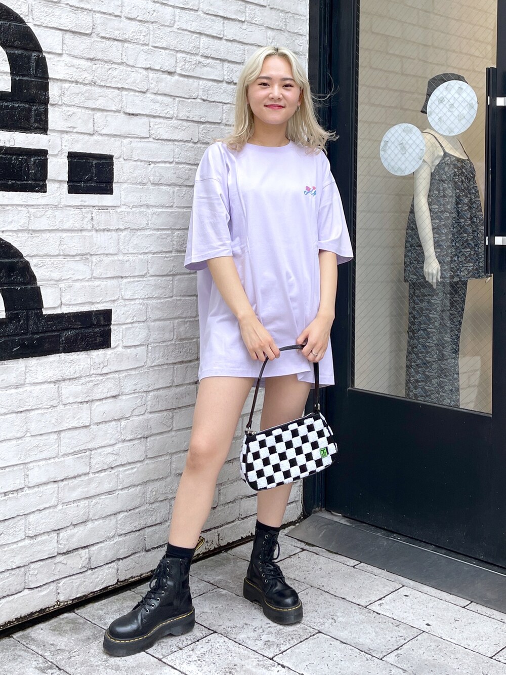 パープル系のTシャツ/カットソー、ホワイト系のハンドバッグを着用したレディースの夏コーディネートの2枚目の写真