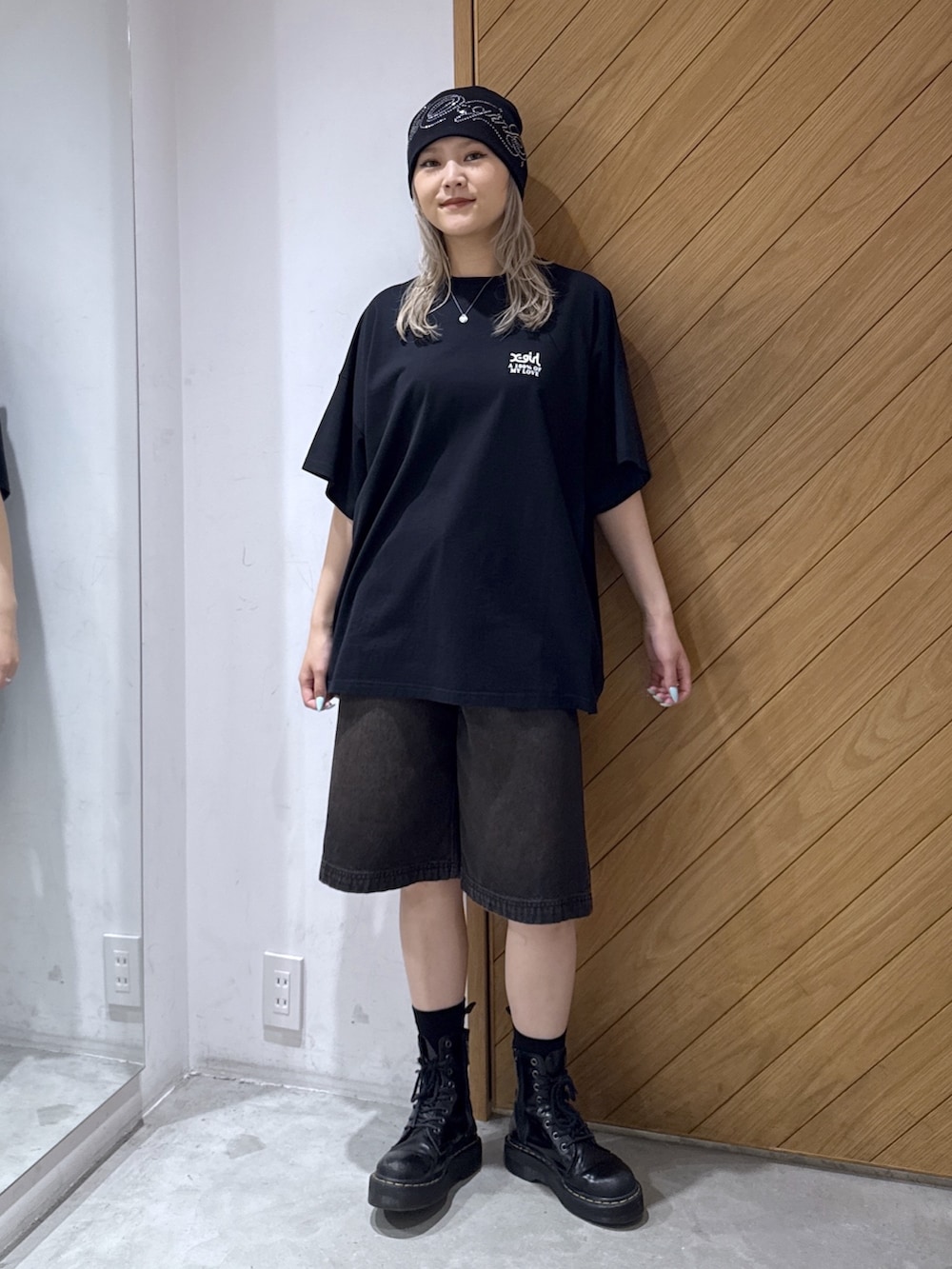 ブラック系のワンピース、ブルー系のデニムパンツを着用したレディースの夏コーディネートの2枚目の写真
