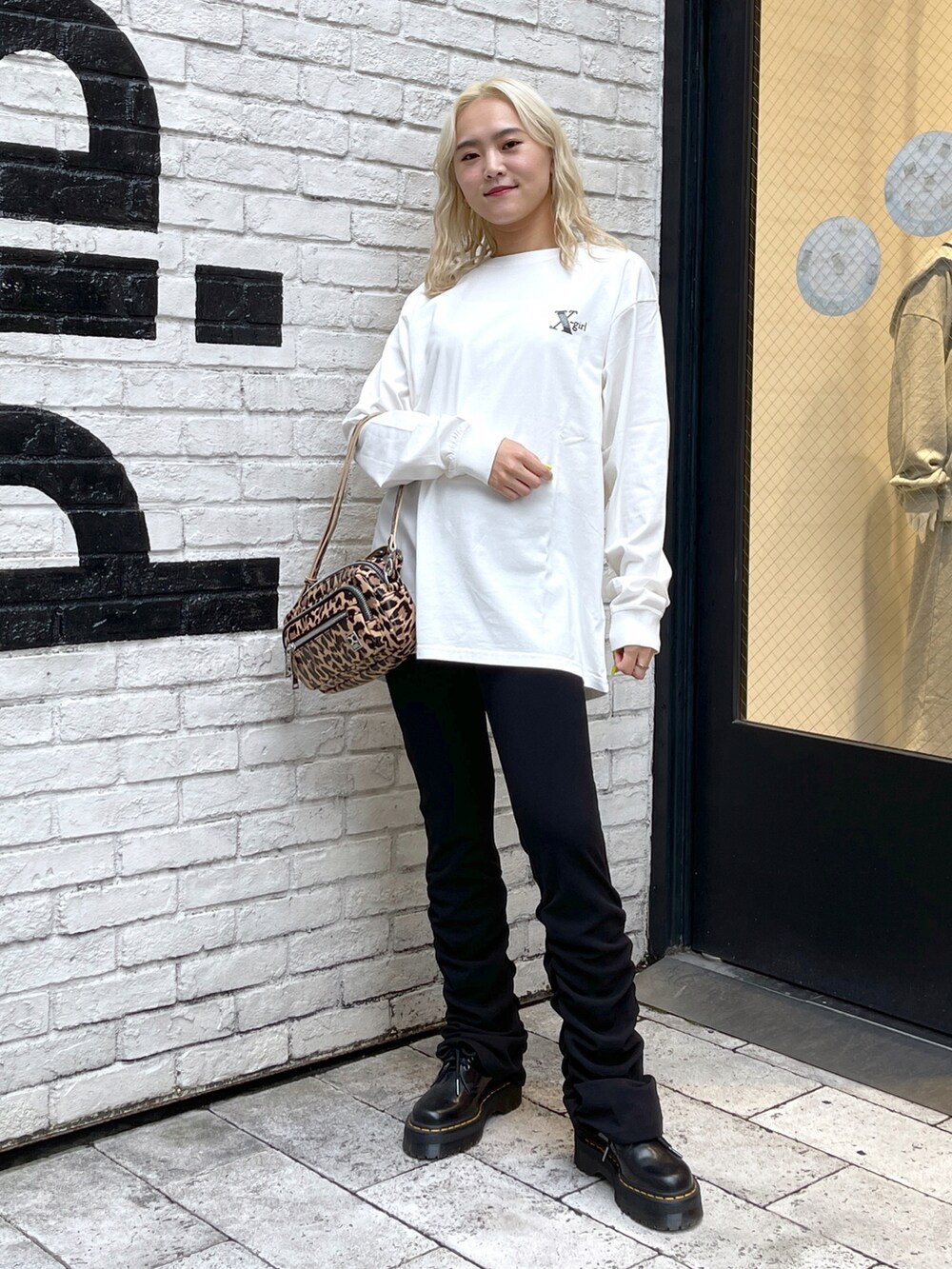 ブラウン系のその他パンツ、ホワイト系のTシャツ/カットソー、ベージュ系のショルダーバッグを着用したレディースの夏コーディネートの2枚目の写真