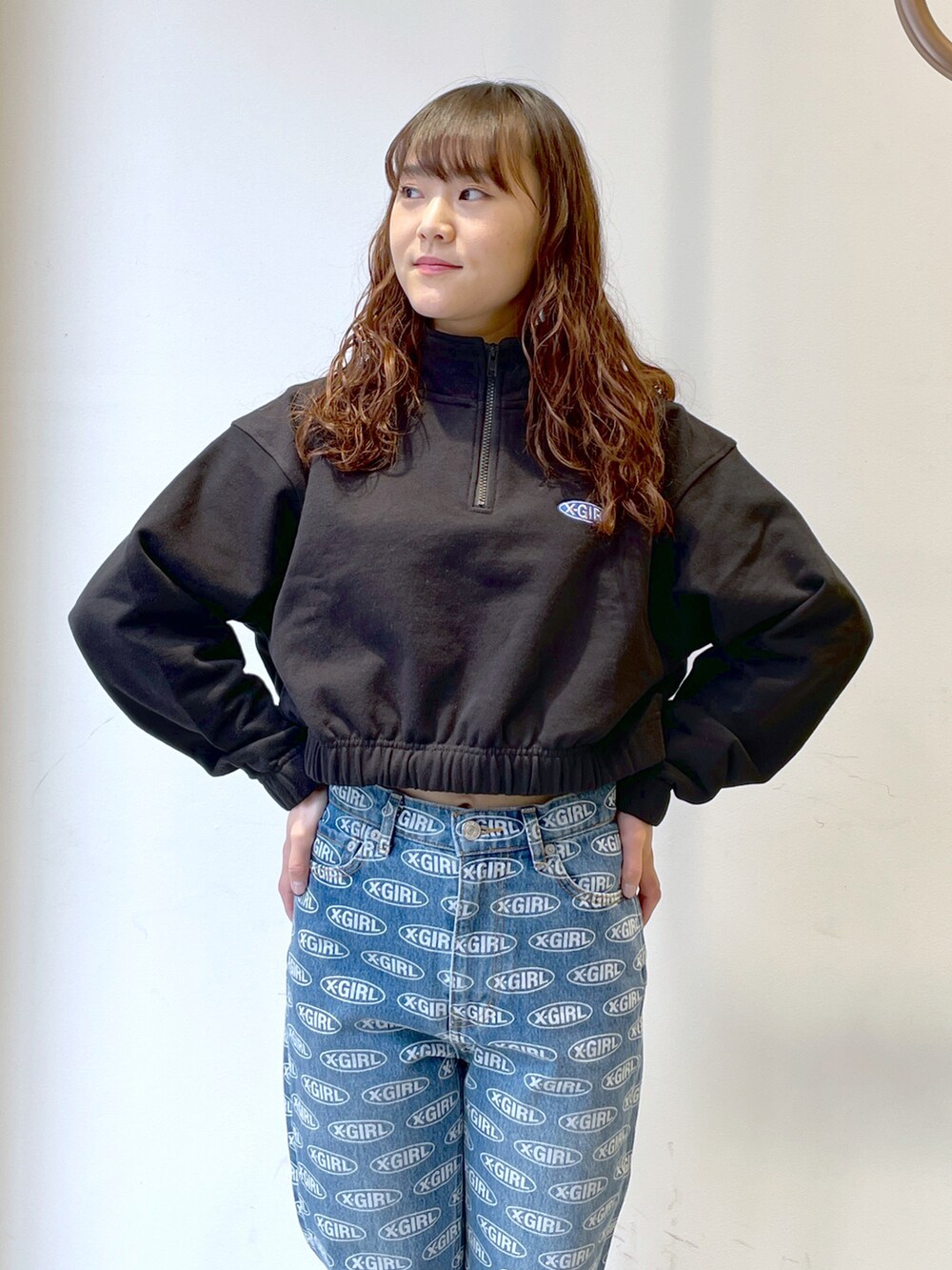 ブラック系のスウェット、ブルー系のデニムパンツ、ホワイト系のトートバッグを着用したレディースの春コーディネートの3枚目の写真