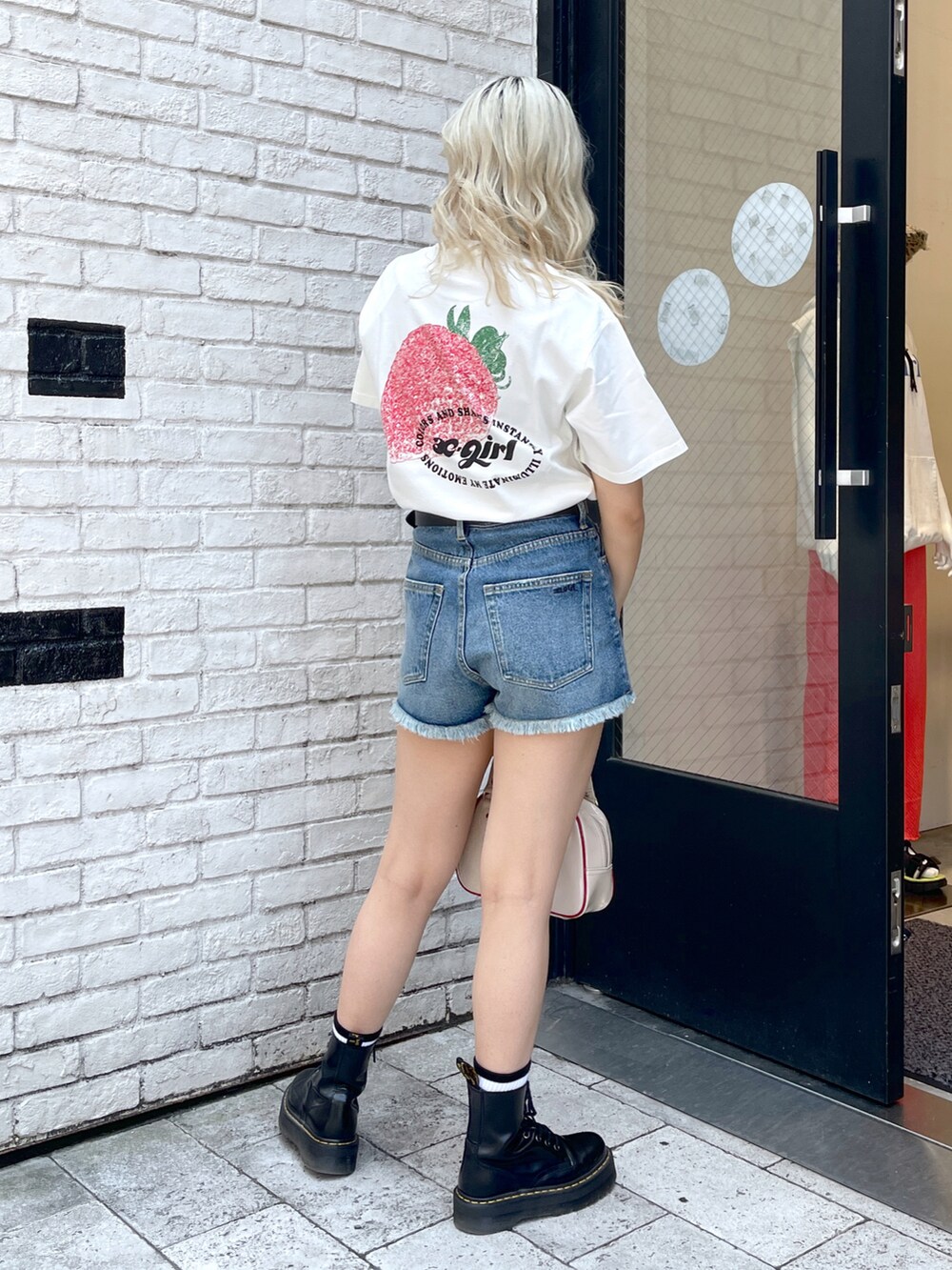 グレー系のTシャツ/カットソー、ブラック系のデニムパンツ、ブラウン系のボストンバッグを着用したレディースの夏コーディネートの2枚目の写真