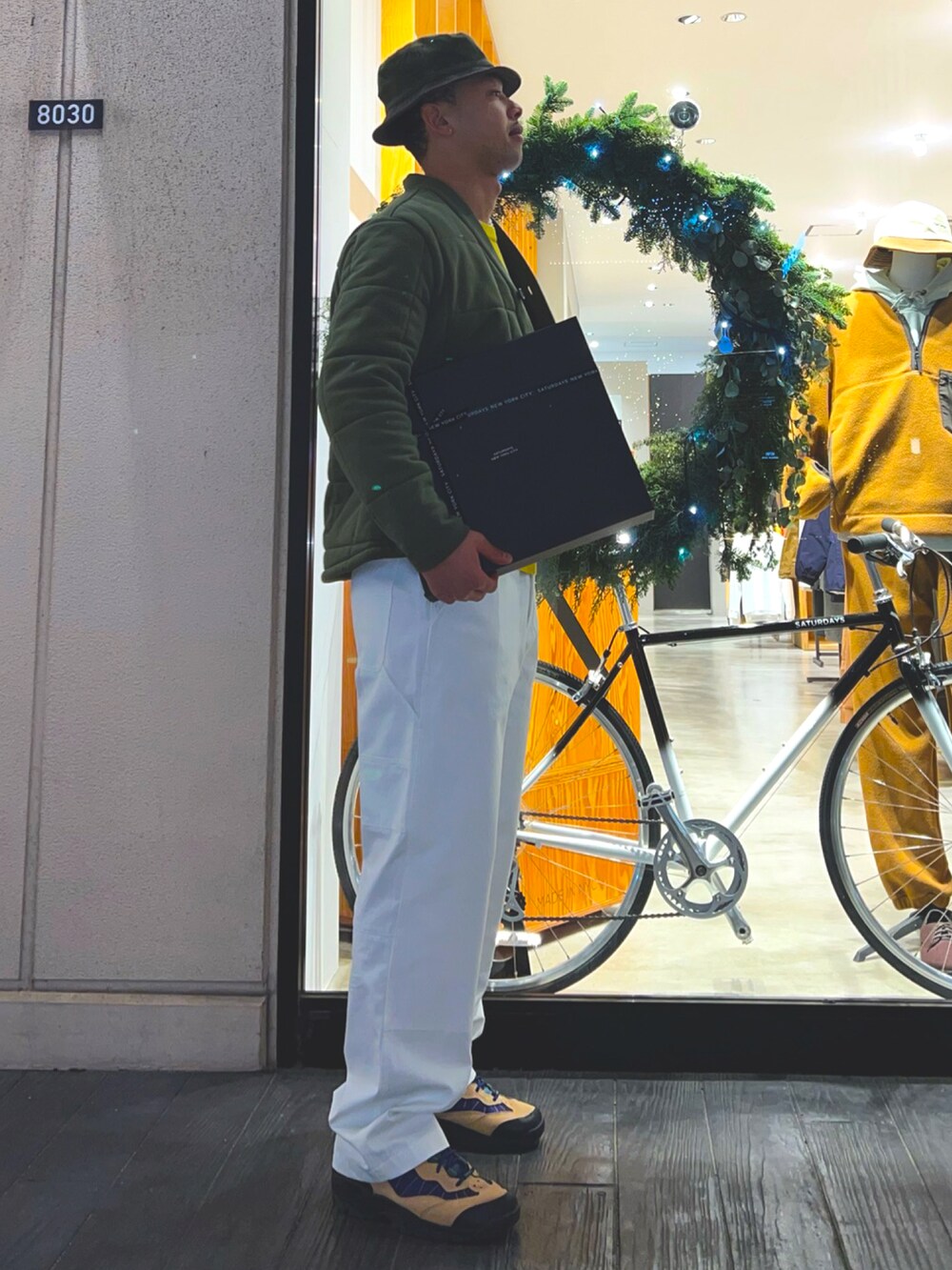 グリーン系のその他アウター、イエロー系のニット/セーター、ブラック系のショルダーバッグを着用したメンズの冬コーディネートの4枚目の写真