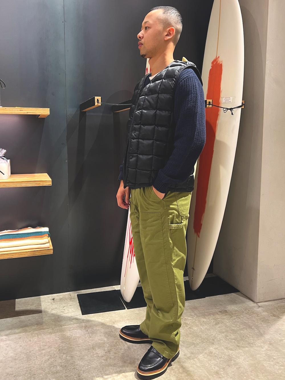 グリーン系のその他パンツ、ブラック系のローファー、ブルー系のニット/セーターを着用したメンズの秋コーディネートの2枚目の写真