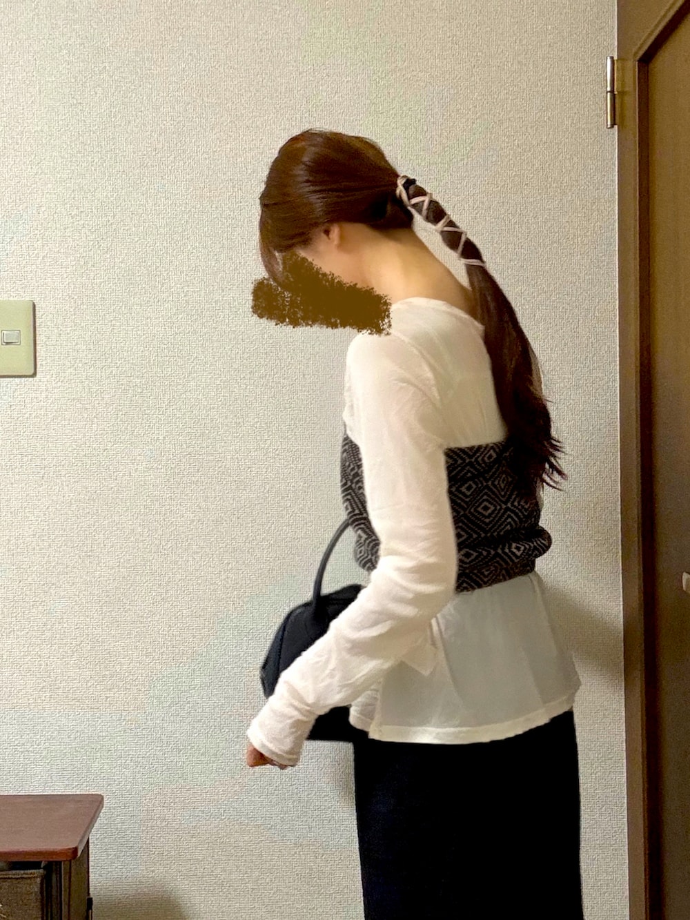 ブラック系のショルダーバッグ、ブラック系のスカート、ブラック系のパンプスを着用したレディースの秋コーディネートの2枚目の写真