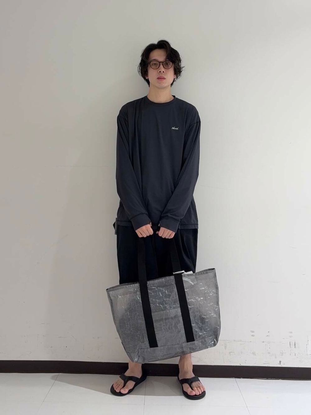 ブルー系のその他パンツ、ブラック系のサンダル、ブラック系のトートバッグを着用したメンズの夏コーディネートの2枚目の写真